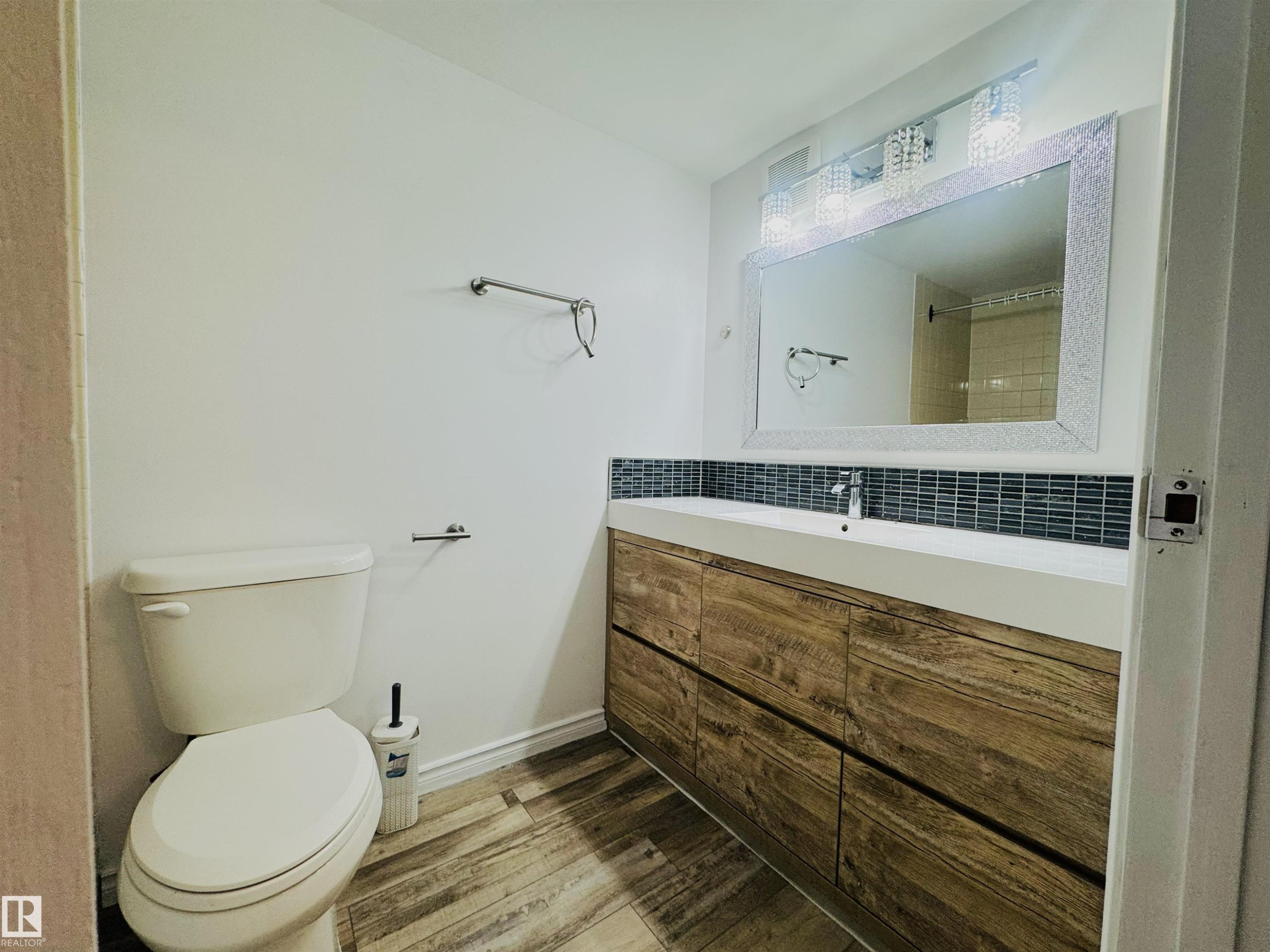 Full bath with vanity, light wood-style flooring, backsplash, and a shower - 309 1624 48 Street, Edmonton, AB - Indoor Photo Showing Bathroom