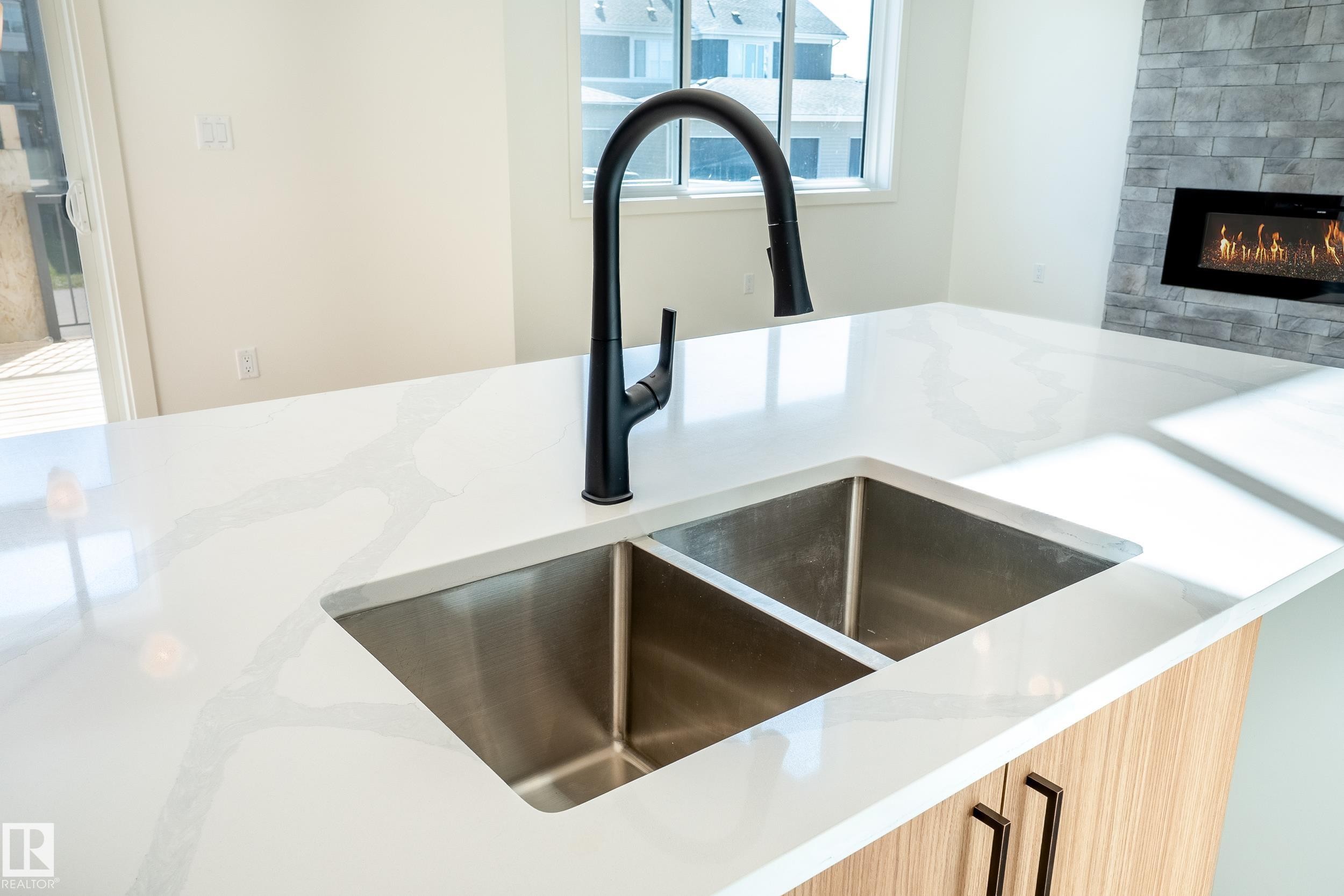119 Lilac Close, Leduc, AB - Indoor Photo Showing Kitchen With Fireplace With Double Sink