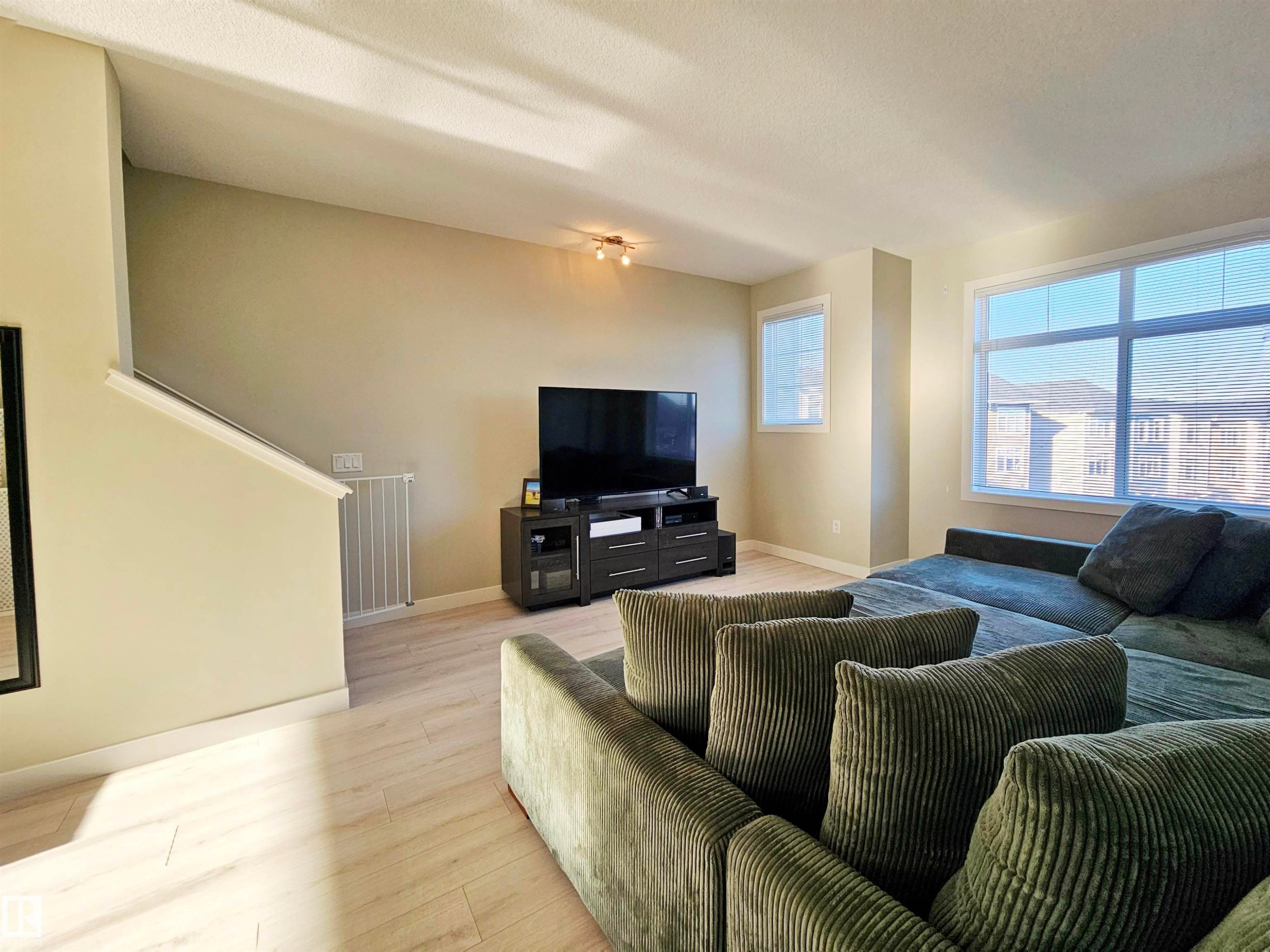 Living room with light wood-style floors and baseboards - 83 600 Bellerose Drive, St. Albert, AB - Indoor Photo Showing Living Room