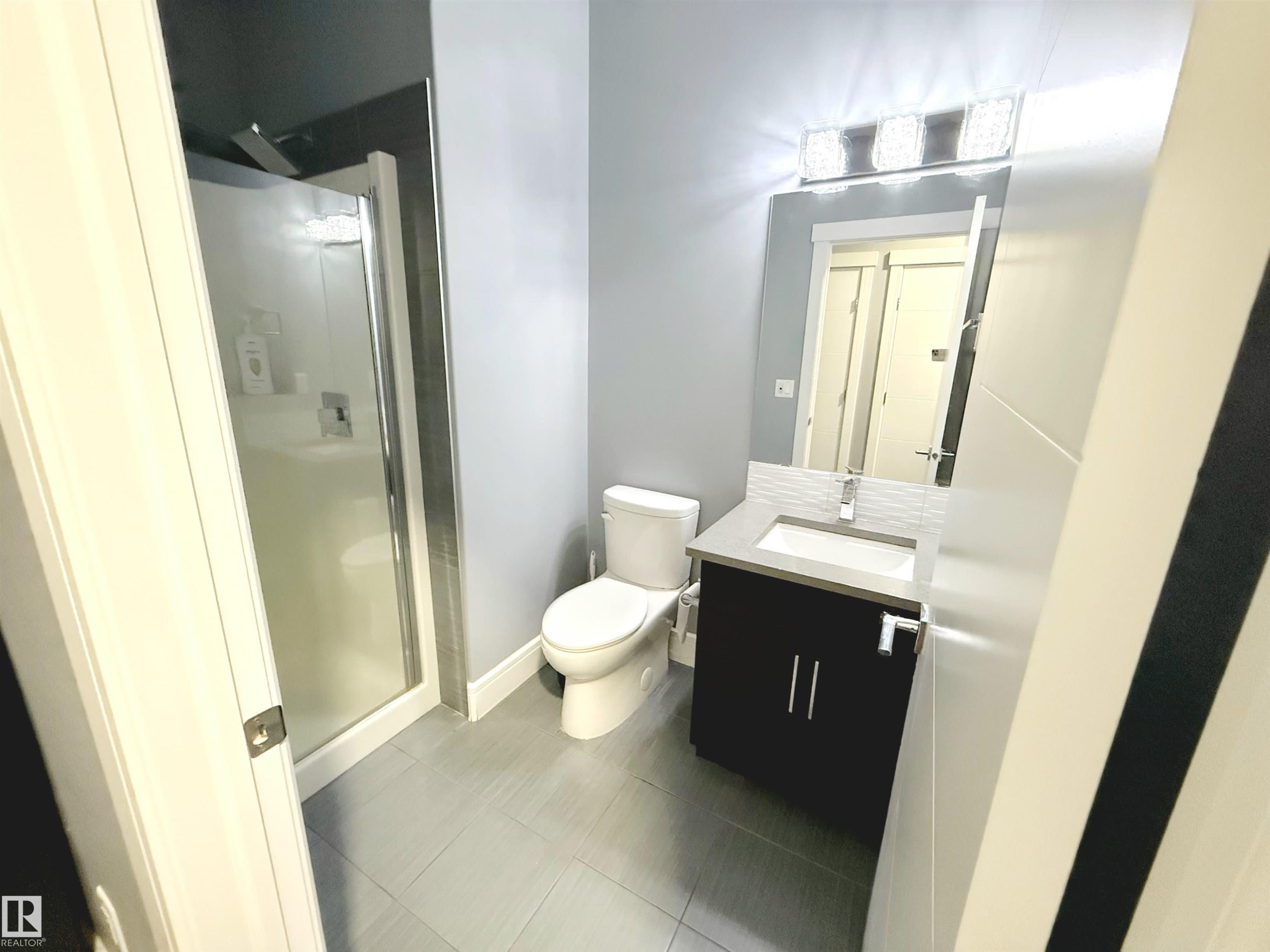 Bathroom featuring vanity, a stall shower, and dark tile patterned floors - 1357 Watt Drive, Edmonton, AB - Indoor Photo Showing Bathroom