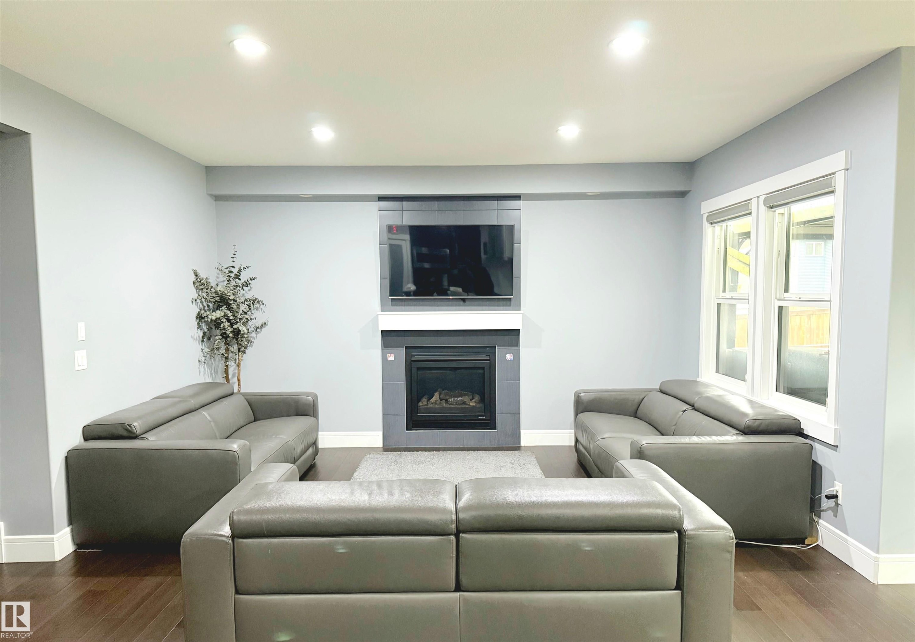 Living room with dark wood finished floors, recessed lighting, and a fireplace - 1357 Watt Drive, Edmonton, AB - Indoor Photo Showing Living Room With Fireplace
