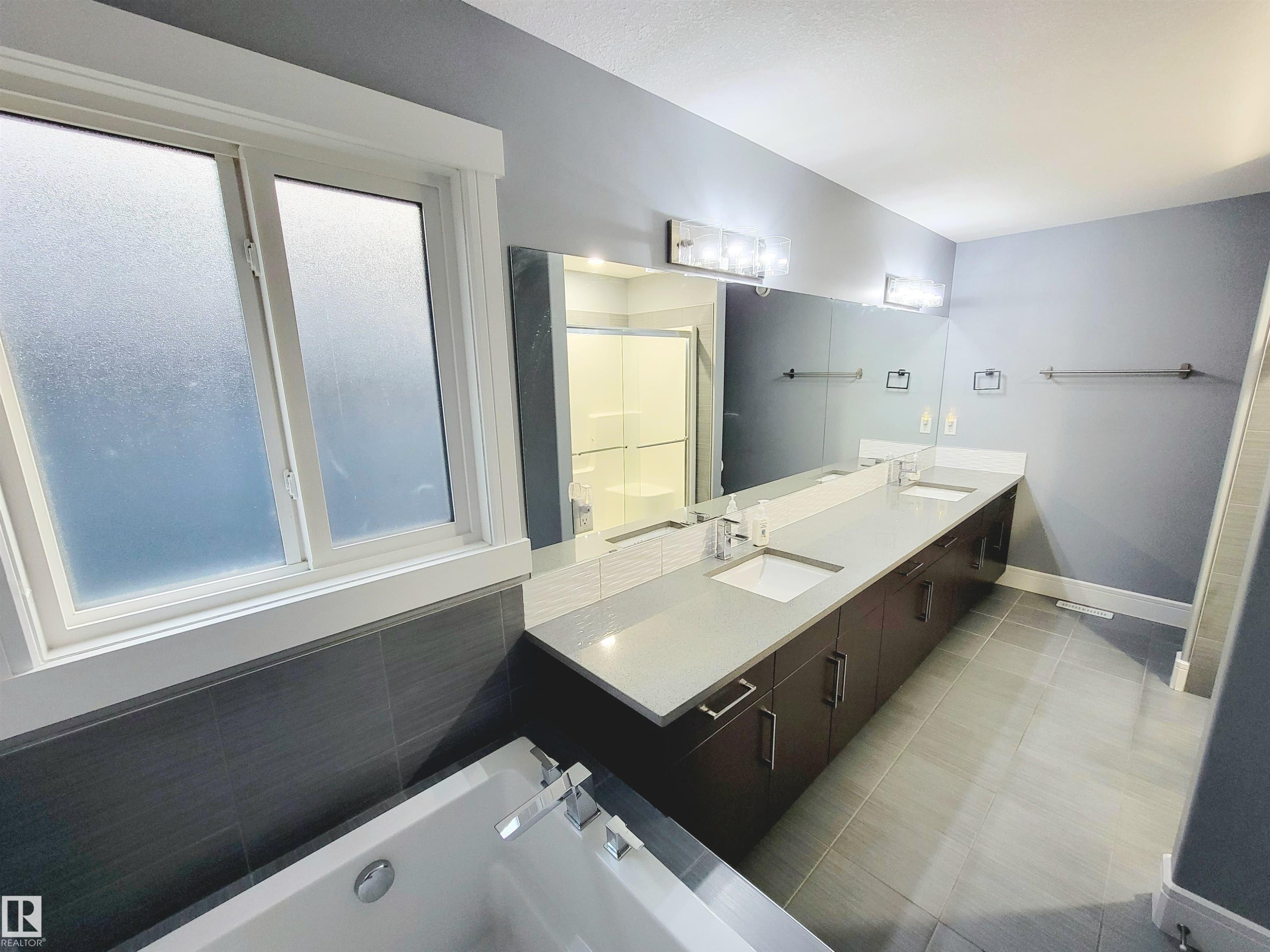 Full bath with double vanity, a tub to relax in, a shower stall, and light tile patterned flooring - 1357 Watt Drive, Edmonton, AB - Indoor Photo Showing Bathroom