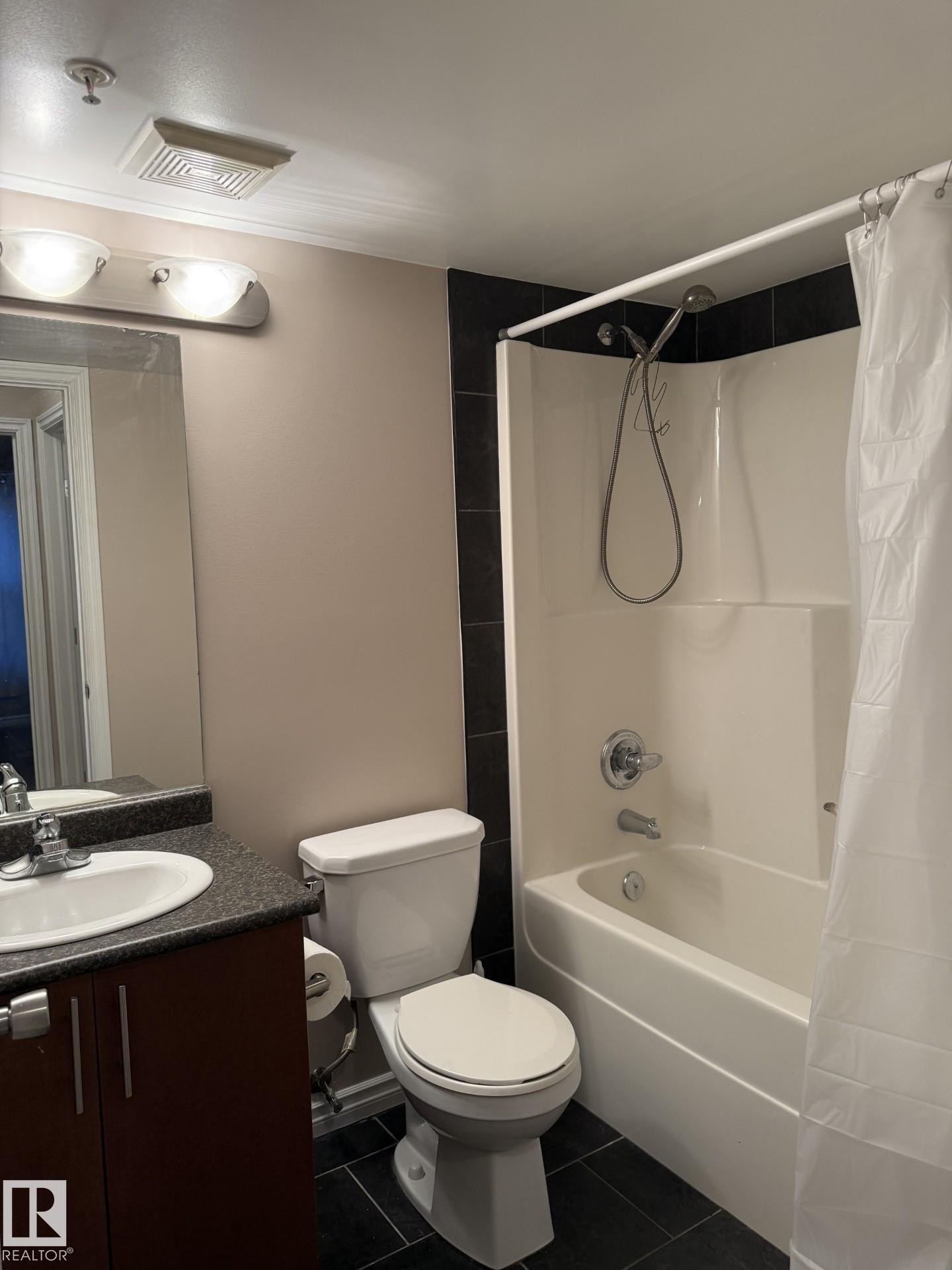 Full bath featuring dark tile patterned flooring, vanity, and shower / tub combo - 303 10118 106 Avenue, Edmonton, AB - Indoor Photo Showing Bathroom