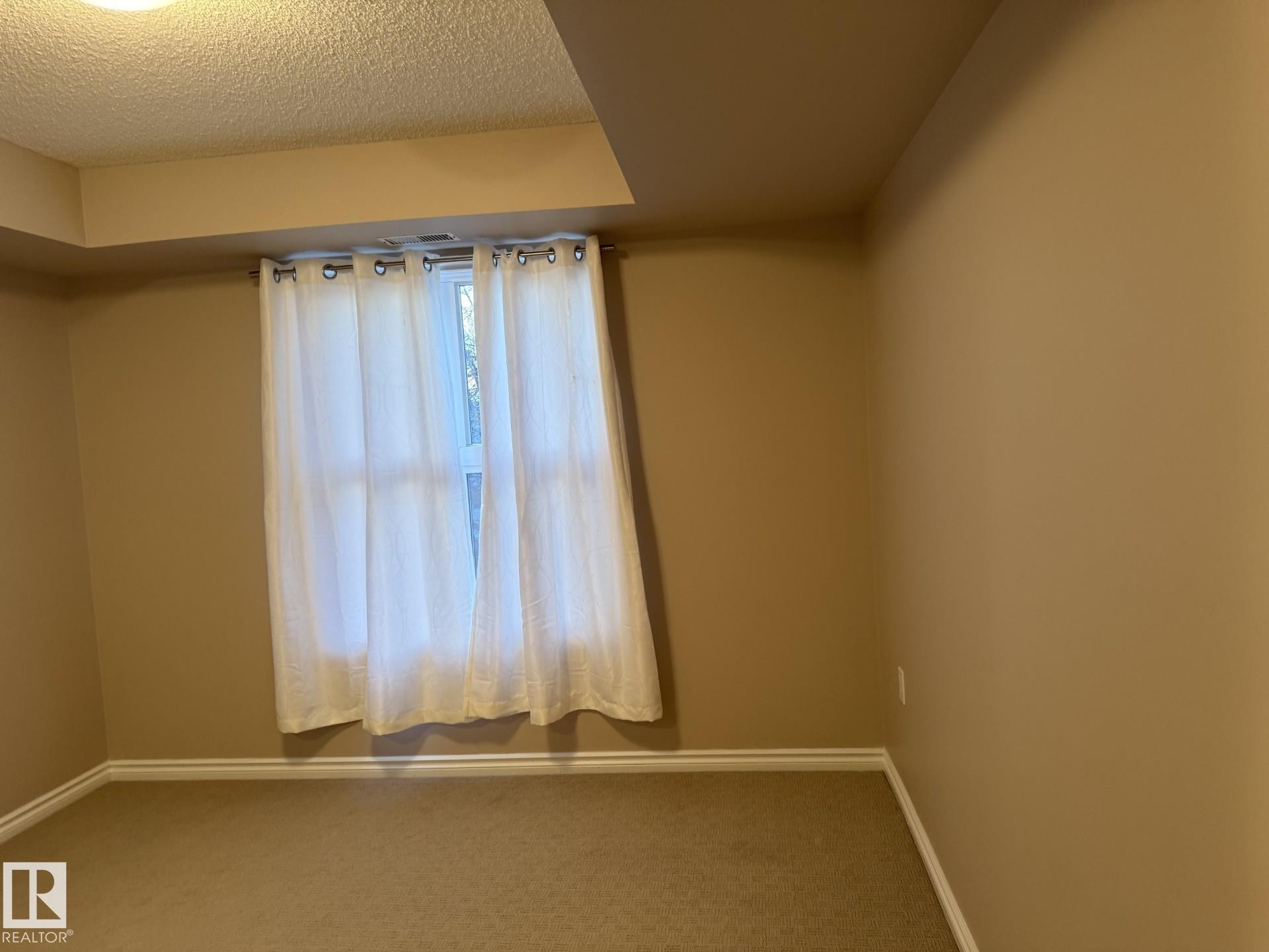 Unfurnished room with carpet flooring and a textured ceiling - 303 10118 106 Avenue, Edmonton, AB - Indoor Photo Showing Other Room