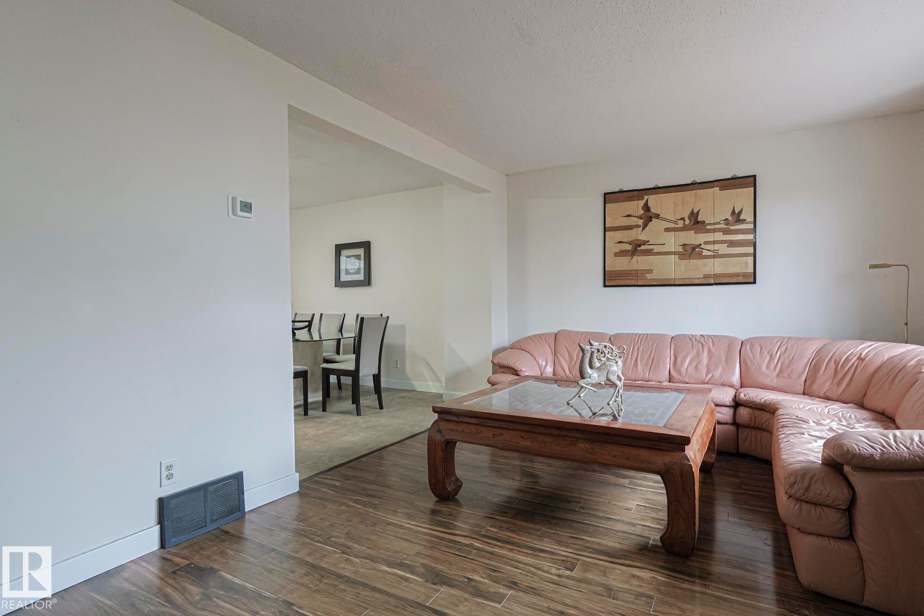 Living room with dark wood-style flooring and baseboards - 51 Belmead Gardens, Edmonton, AB - Indoor Photo Showing Living Room