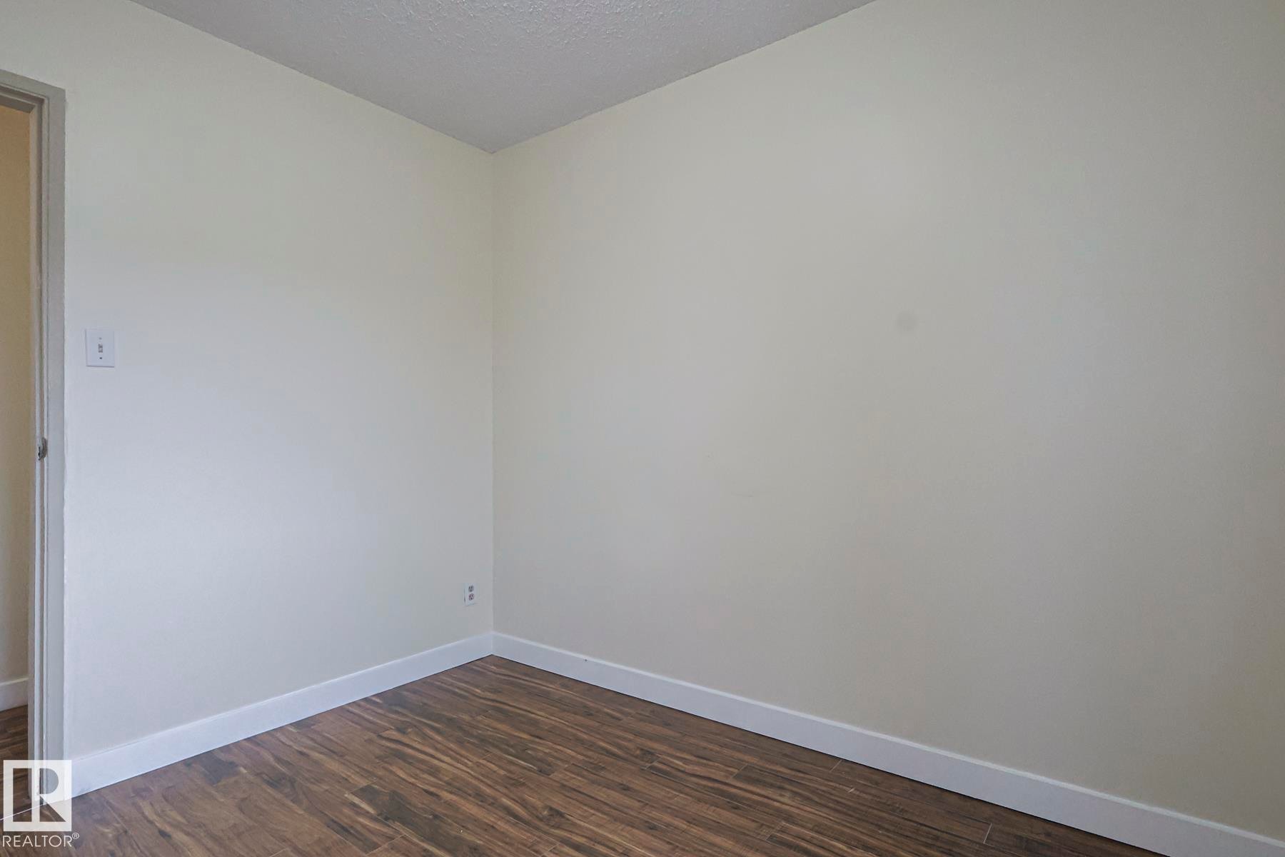 Spare room with dark wood-type flooring and a textured ceiling - 51 Belmead Gardens, Edmonton, AB - Indoor Photo Showing Other Room