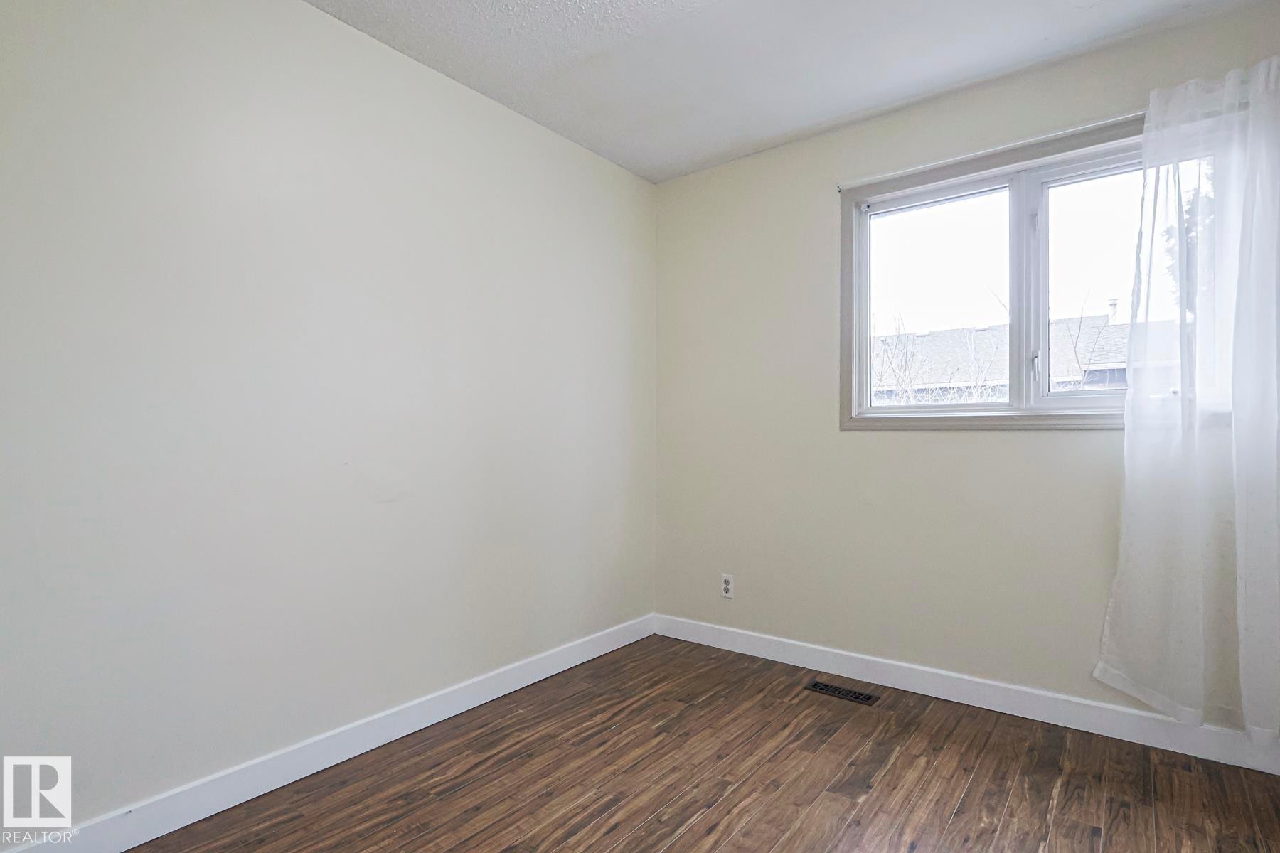 Empty room with baseboards and dark wood-style flooring - 51 Belmead Gardens, Edmonton, AB - Indoor Photo Showing Other Room