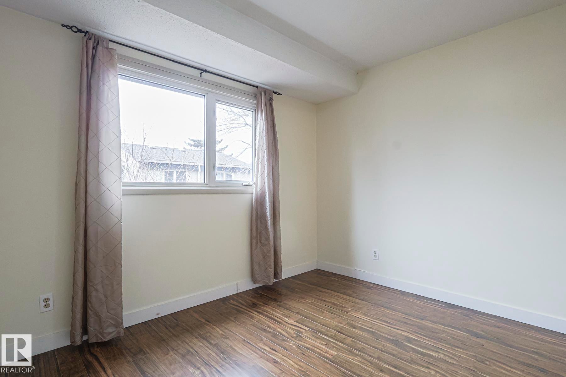 Unfurnished room with dark wood-style flooring and baseboards - 51 Belmead Gardens, Edmonton, AB - Indoor Photo Showing Other Room