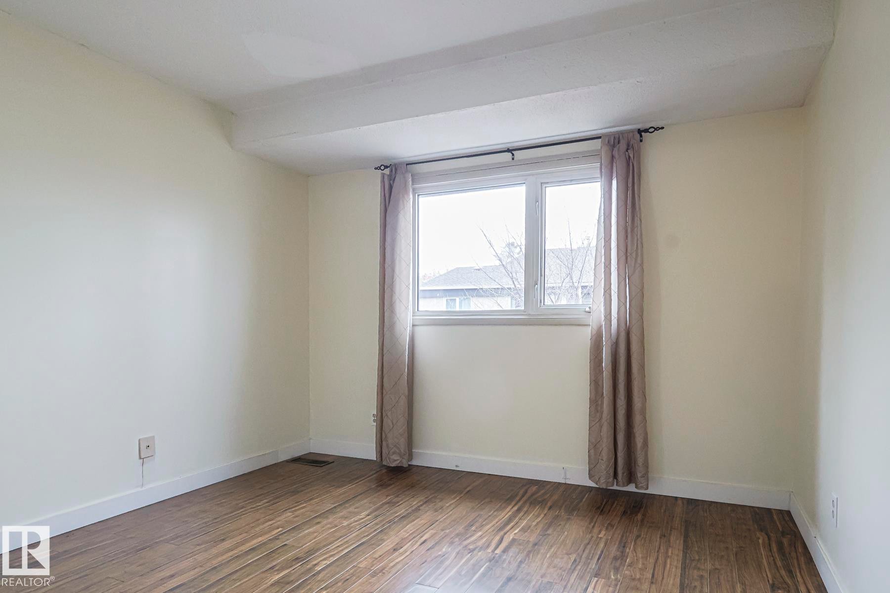 Spare room with dark wood-type flooring and baseboards - 51 Belmead Gardens, Edmonton, AB - Indoor Photo Showing Other Room