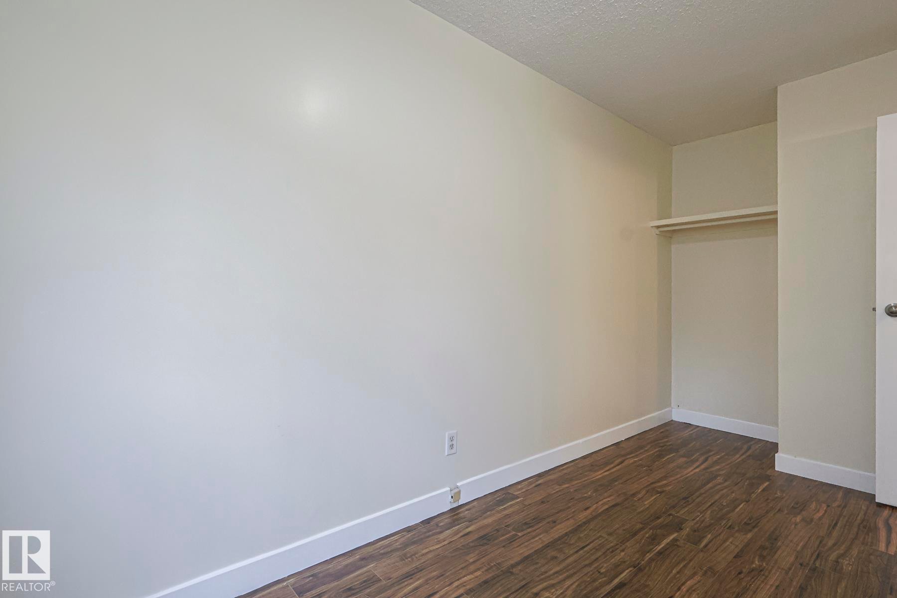 Unfurnished bedroom with dark wood finished floors, a closet, and a textured ceiling - 51 Belmead Gardens, Edmonton, AB - Indoor Photo Showing Other Room