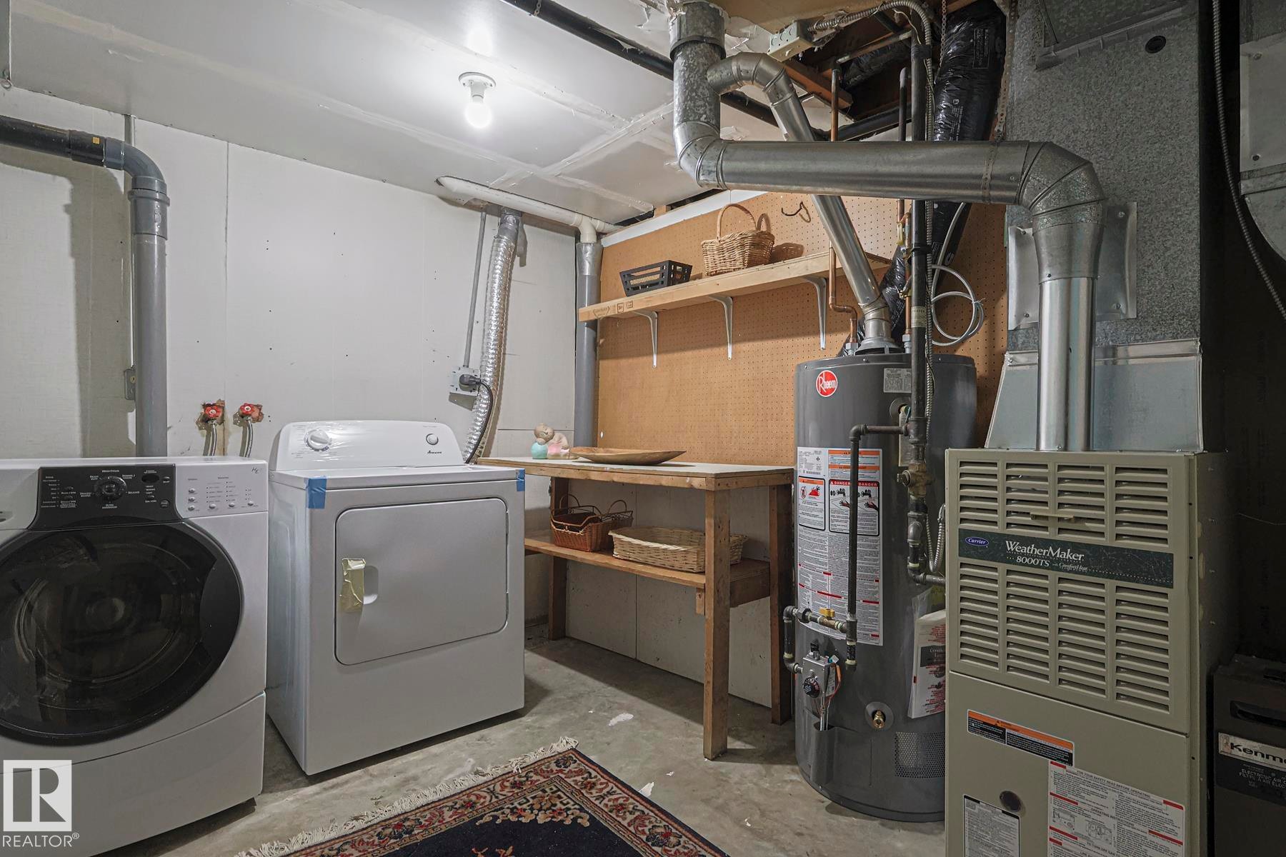 Laundry area with concrete floors, gas water heater, heating unit, and washing machine and dryer - 51 Belmead Gardens, Edmonton, AB - Indoor Photo Showing Laundry Room