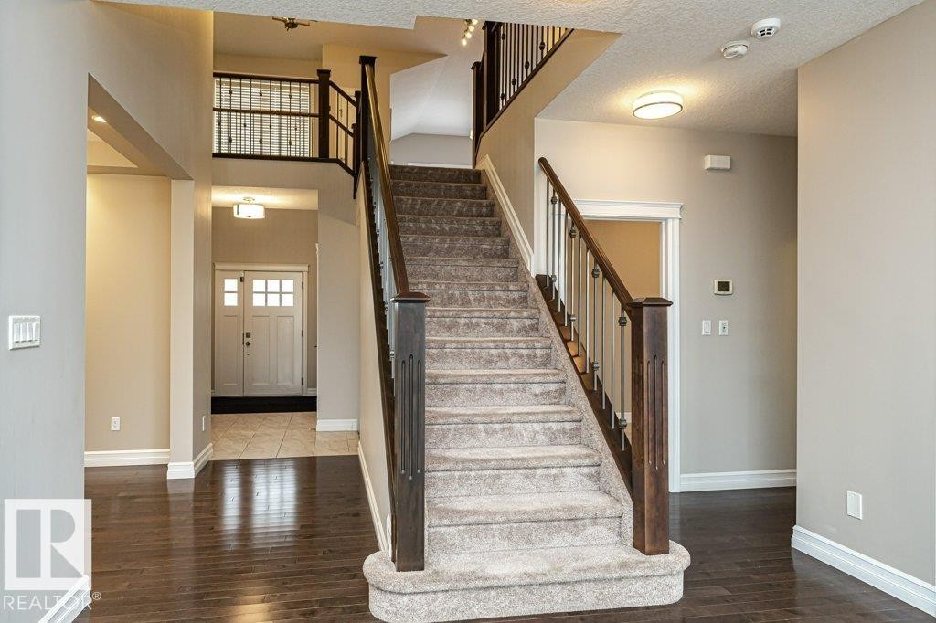 Staircase with wood-type flooring and a textured ceiling - 3198 Winspear Crescent Sw, Edmonton, AB - Indoor Photo Showing Other Room
