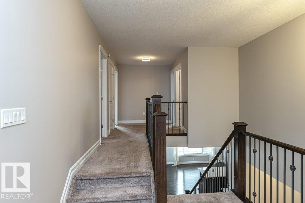 Stairs featuring a textured ceiling and carpet - 3198 Winspear Crescent Sw, Edmonton, AB - Indoor Photo Showing Other Room