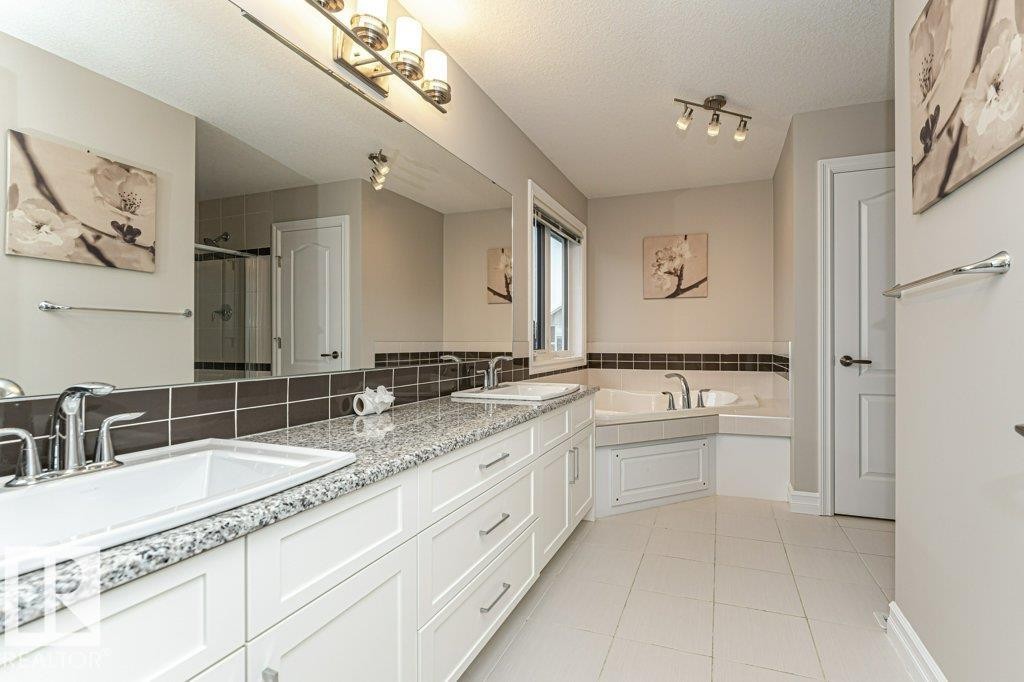 Full bath featuring double vanity, a stall shower, light tile patterned flooring, a garden tub, and a textured ceiling - 3198 Winspear Crescent Sw, Edmonton, AB - Indoor Photo Showing Bathroom