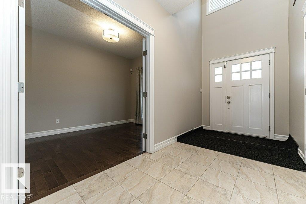 Entryway with light wood-style floors, a high ceiling, healthy amount of natural light, and a textured ceiling - 3198 Winspear Crescent Sw, Edmonton, AB - Indoor Photo Showing Other Room