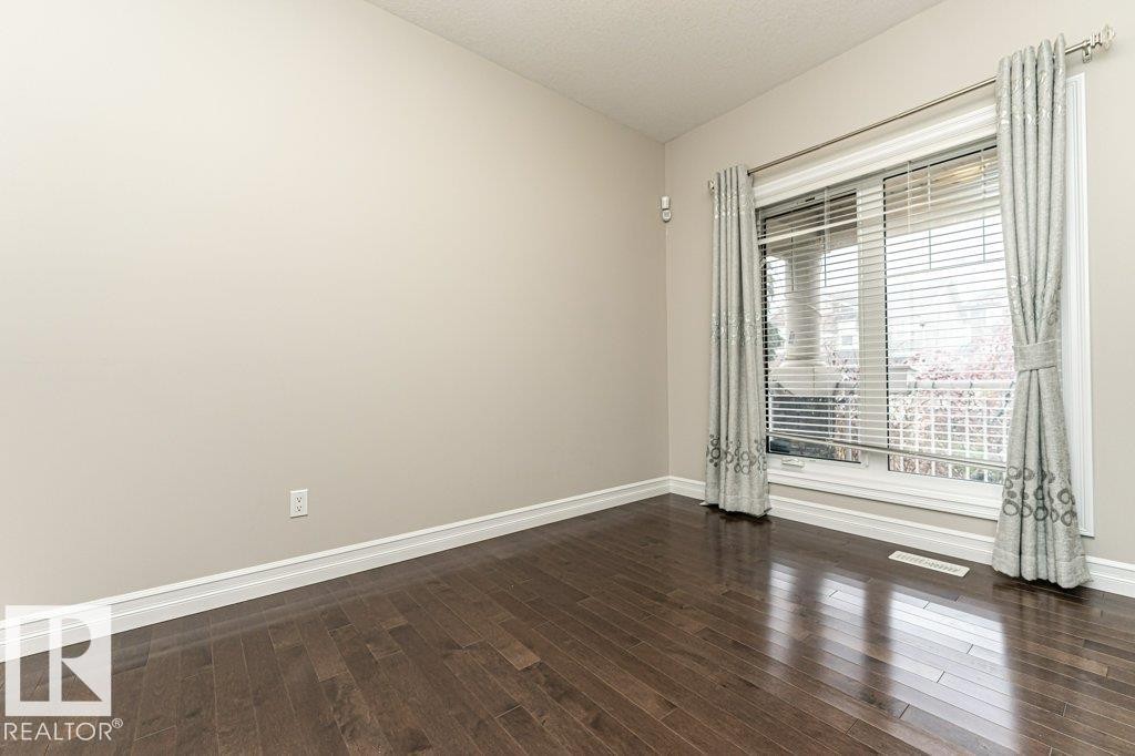 Unfurnished room with dark wood-type flooring and a textured ceiling - 3198 Winspear Crescent Sw, Edmonton, AB - Indoor Photo Showing Other Room