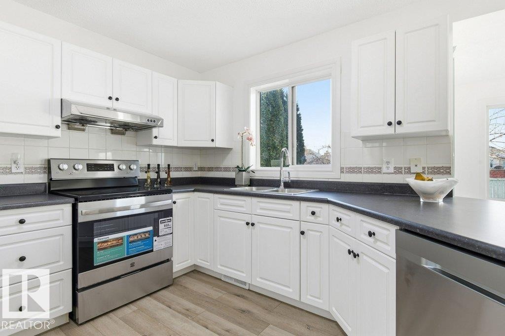Kitchen with appliances with stainless steel finishes, white cabinets, and tasteful backsplash - 1112 118A Street Nw, Edmonton, AB - Indoor Photo Showing Kitchen