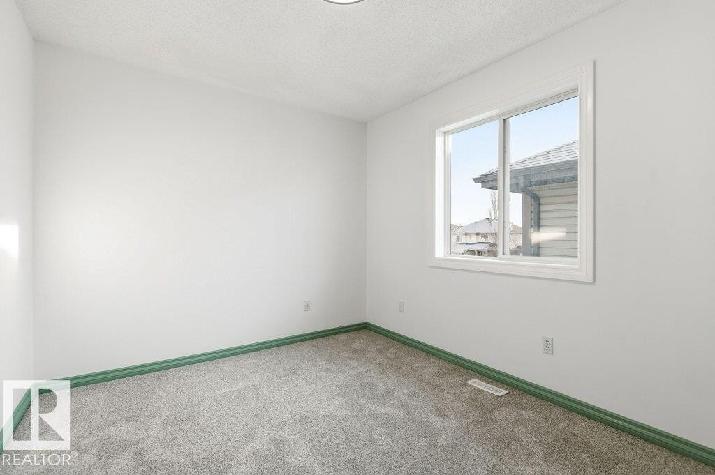 Spare room with a textured ceiling and carpet floors - 1112 118A Street Nw, Edmonton, AB - Indoor Photo Showing Other Room