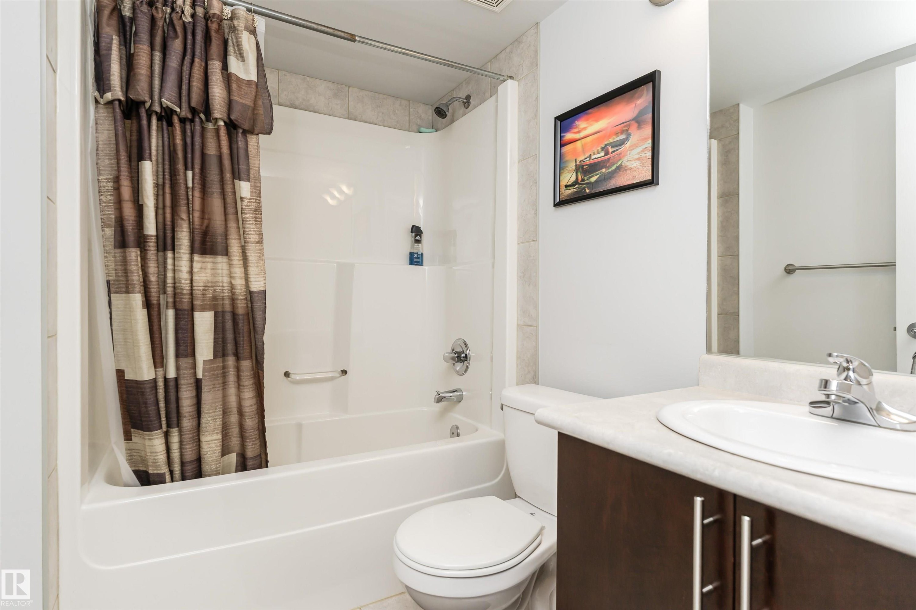 Full bath featuring shower / bathtub combination with curtain and vanity - 107 10118 106 Avenue, Edmonton, AB - Indoor Photo Showing Bathroom