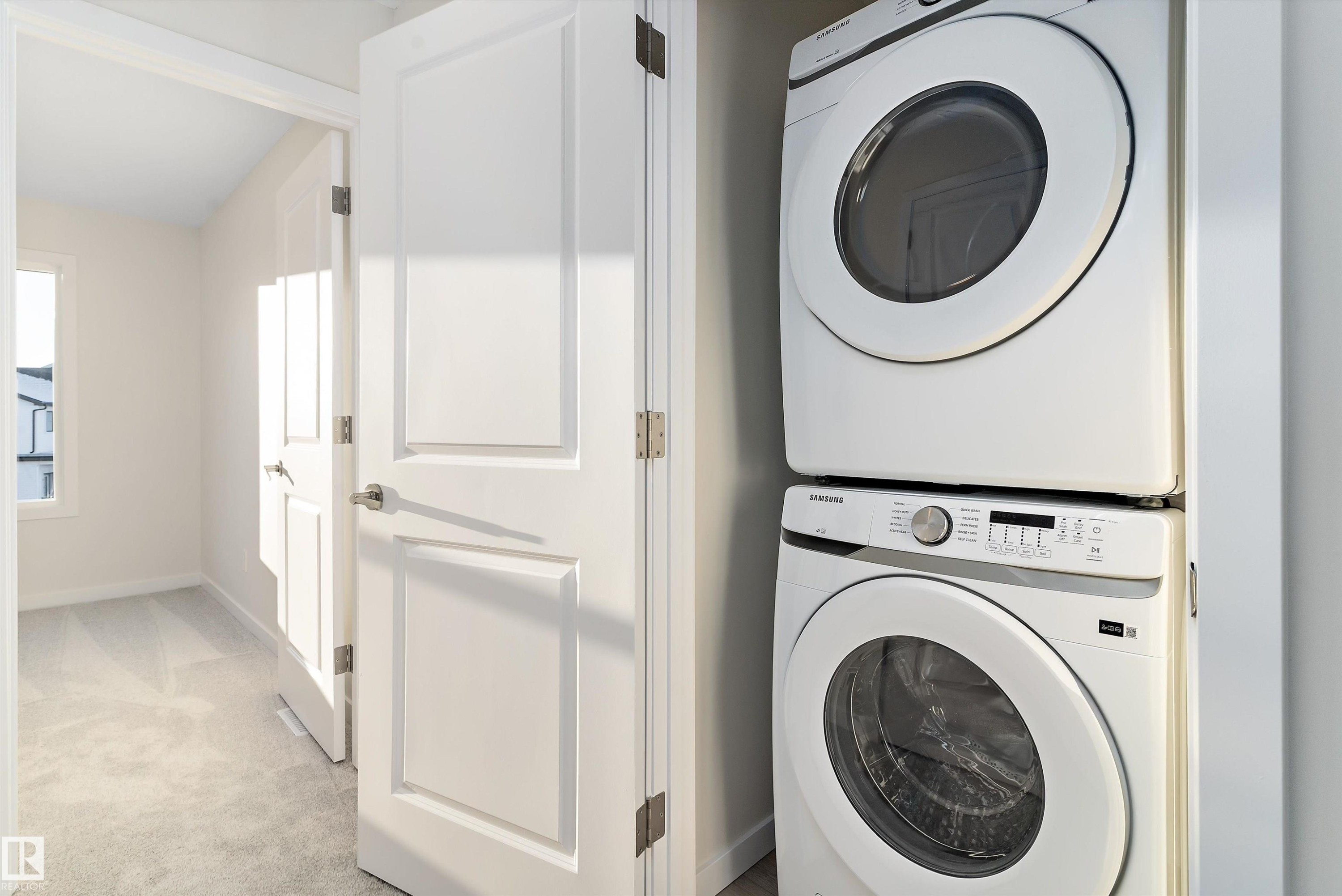 Laundry room featuring light colored carpet and stacked washer and clothes dryer - 823 Rowan Close, Edmonton, AB - Indoor Photo Showing Laundry Room