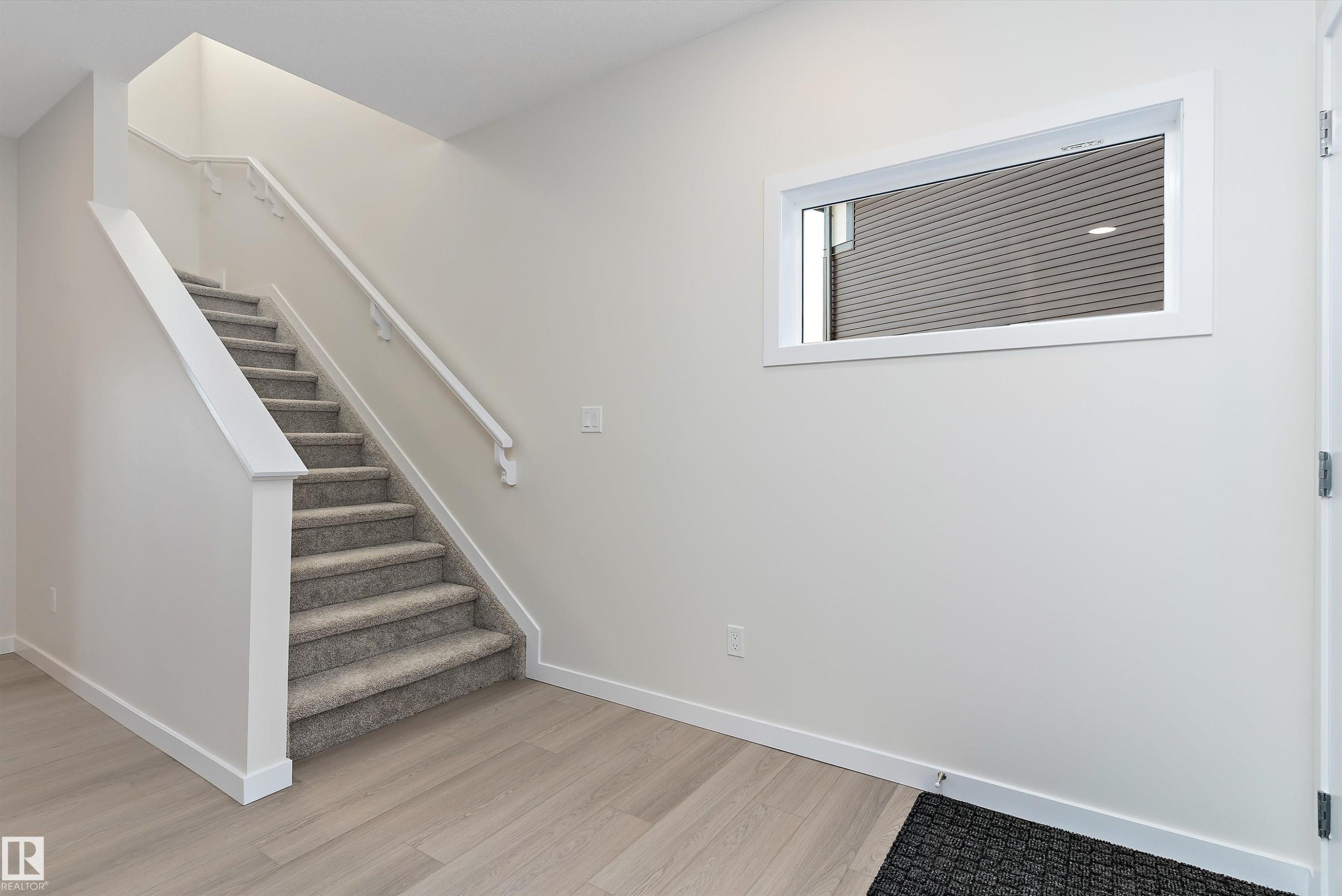 Stairs featuring wood finished floors and baseboards - 823 Rowan Close, Edmonton, AB - Indoor Photo Showing Other Room