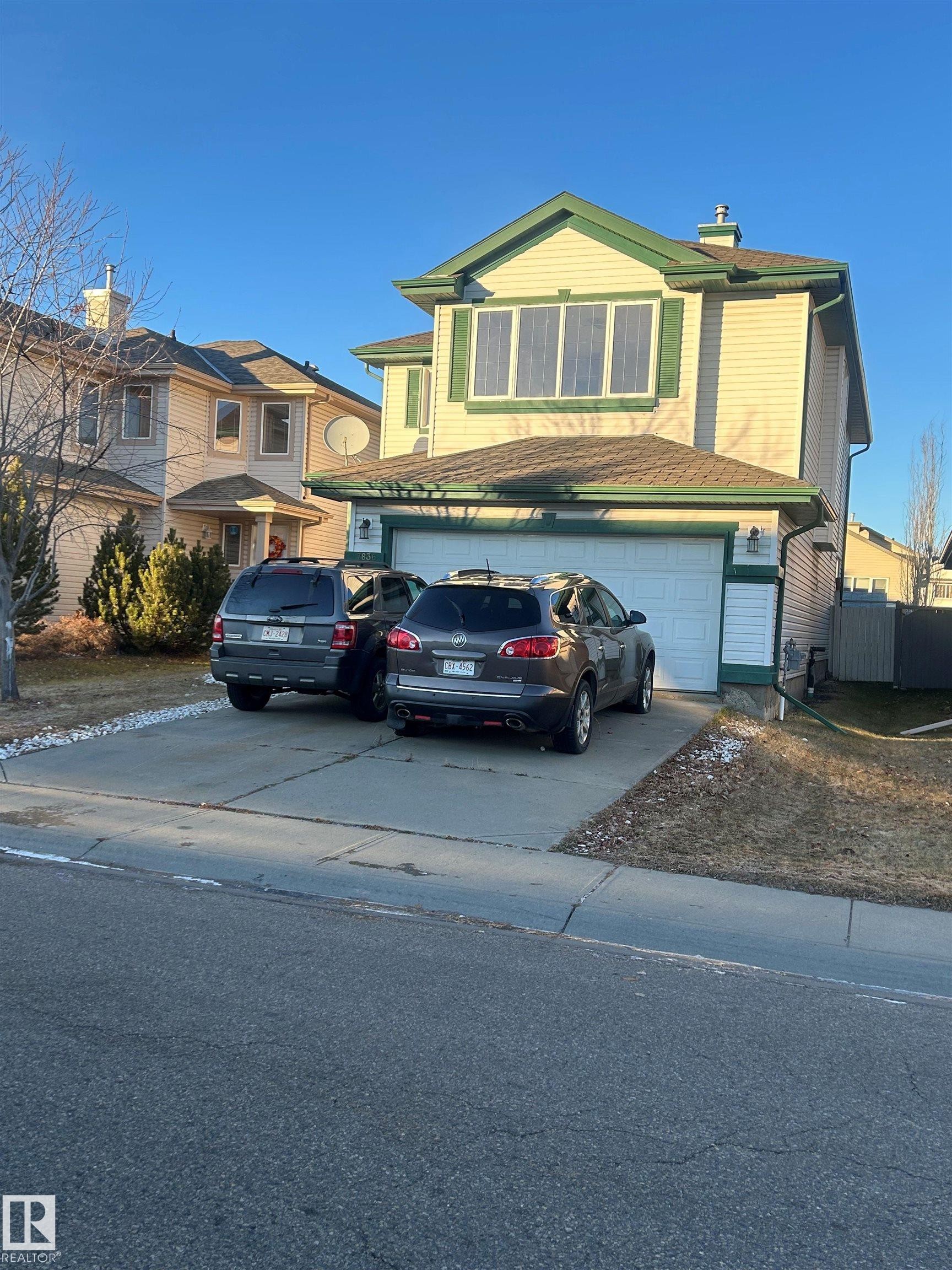 Traditional-style house featuring concrete driveway, a chimney, and a garage - 7836 7 Avenue, Edmonton, AB - Outdoor