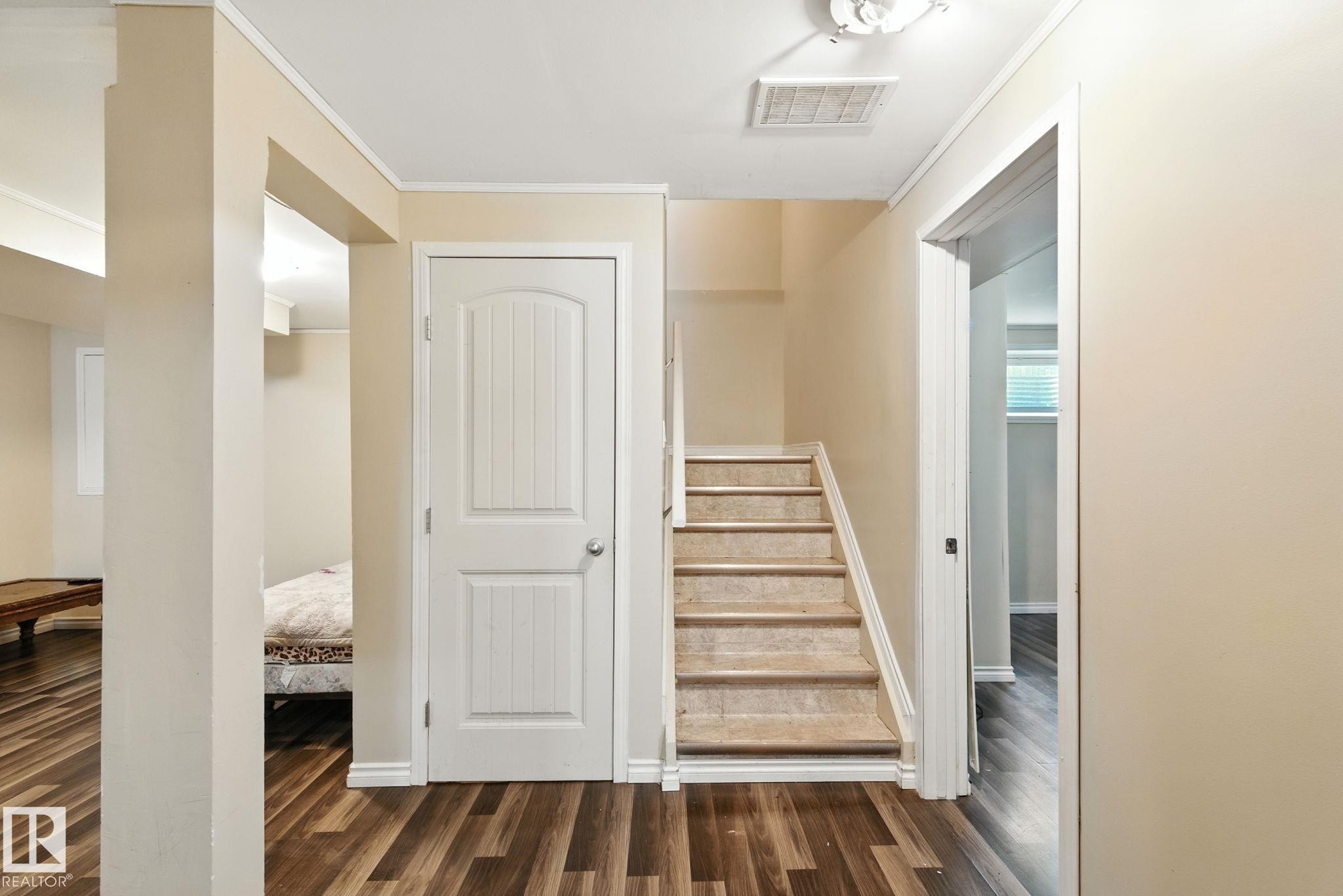 Stairs featuring wood finished floors and ornamental molding - 7836 7 Avenue, Edmonton, AB - Indoor Photo Showing Other Room