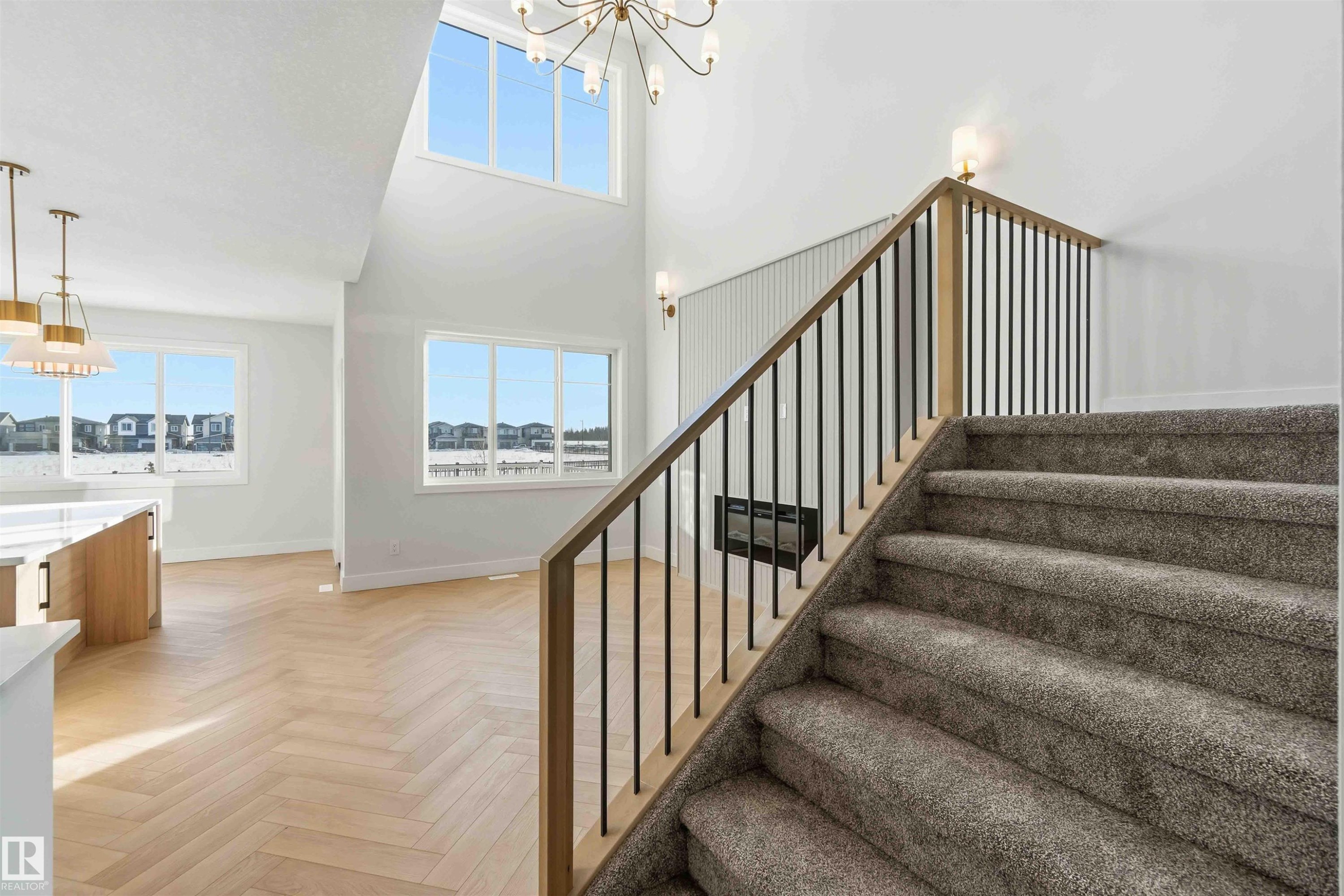 Stairs featuring suspended lighting, parquet floors, a high ceiling, and healthy amount of natural light - 94 Eldridge Pointe, St. Albert, AB - Indoor Photo Showing Other Room