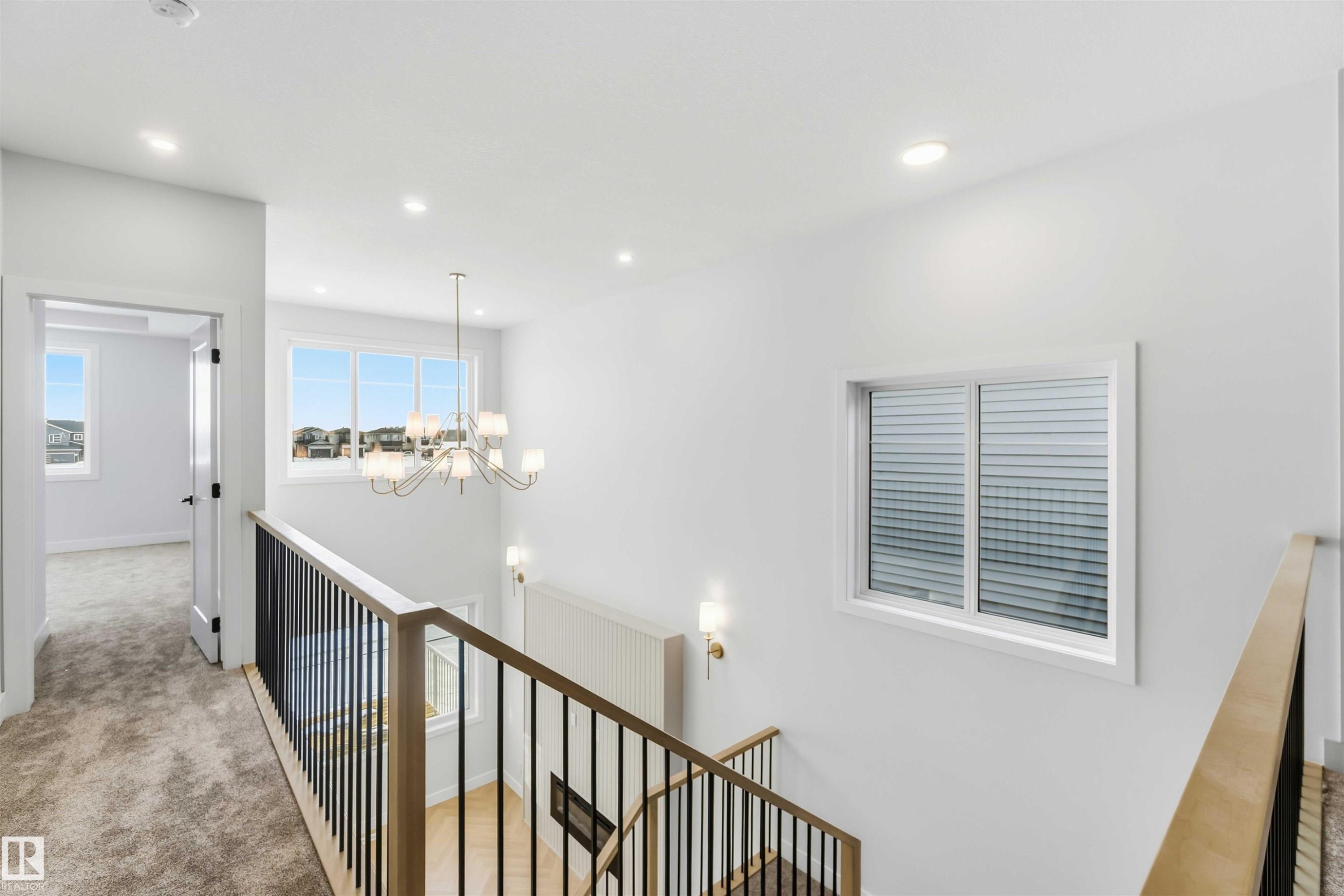 Corridor featuring an upstairs landing, suspended lighting, and light colored carpet - 94 Eldridge Pointe, St. Albert, AB - Indoor Photo Showing Other Room