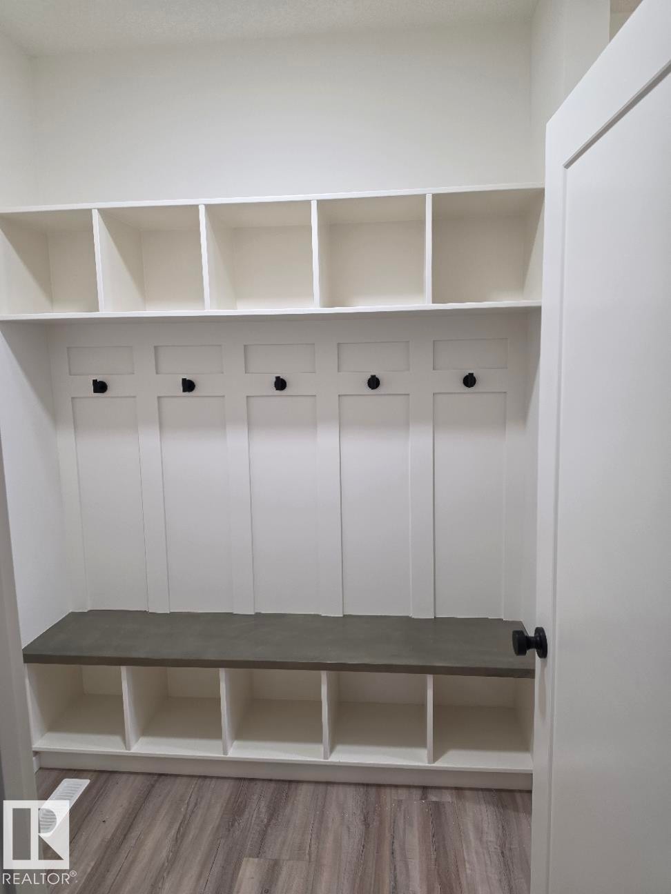 Custom built-in storage unit with a gray-toned bench, open shelving, and individual cubbies - 7706 174A Avenue, Edmonton, AB - Indoor With Storage