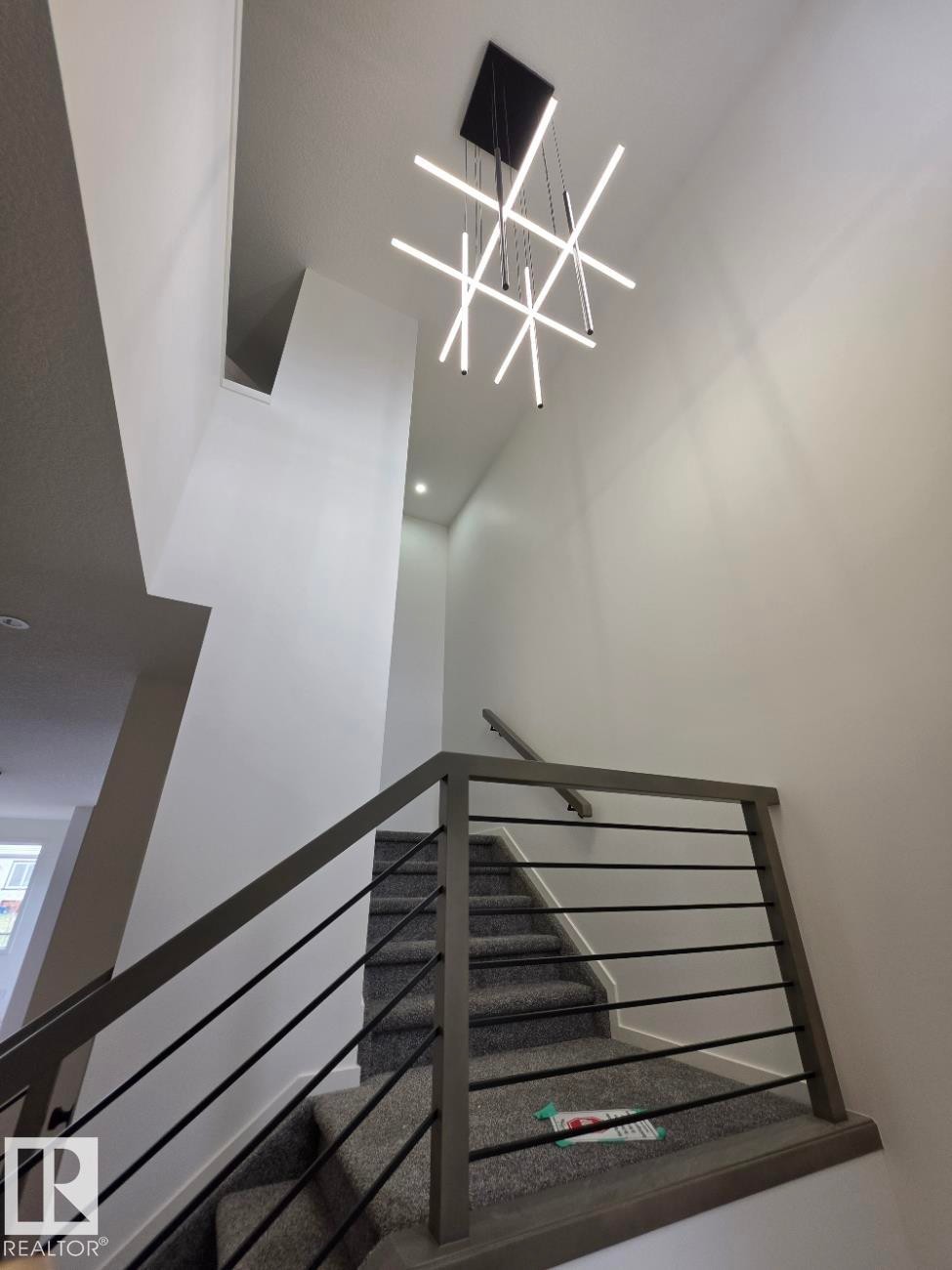 Two-story entryway featuring a contemporary chandelier with linear light fixtures and recessed lighting - 7706 174A Avenue, Edmonton, AB - Indoor Photo Showing Other Room