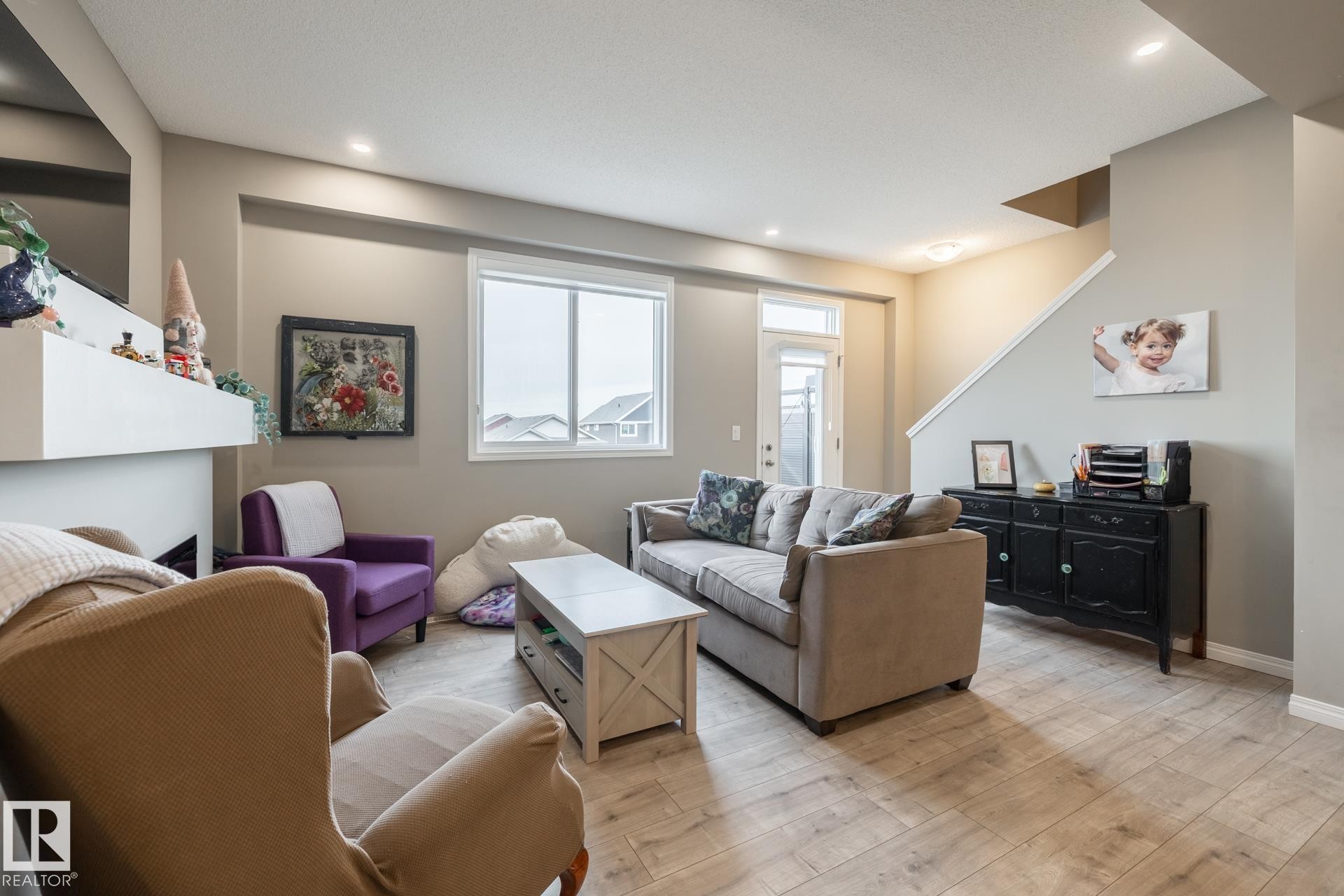 Living area with light wood-style flooring and baseboards - 5 2072 Wonnacott Way, Edmonton, AB - Indoor Photo Showing Living Room