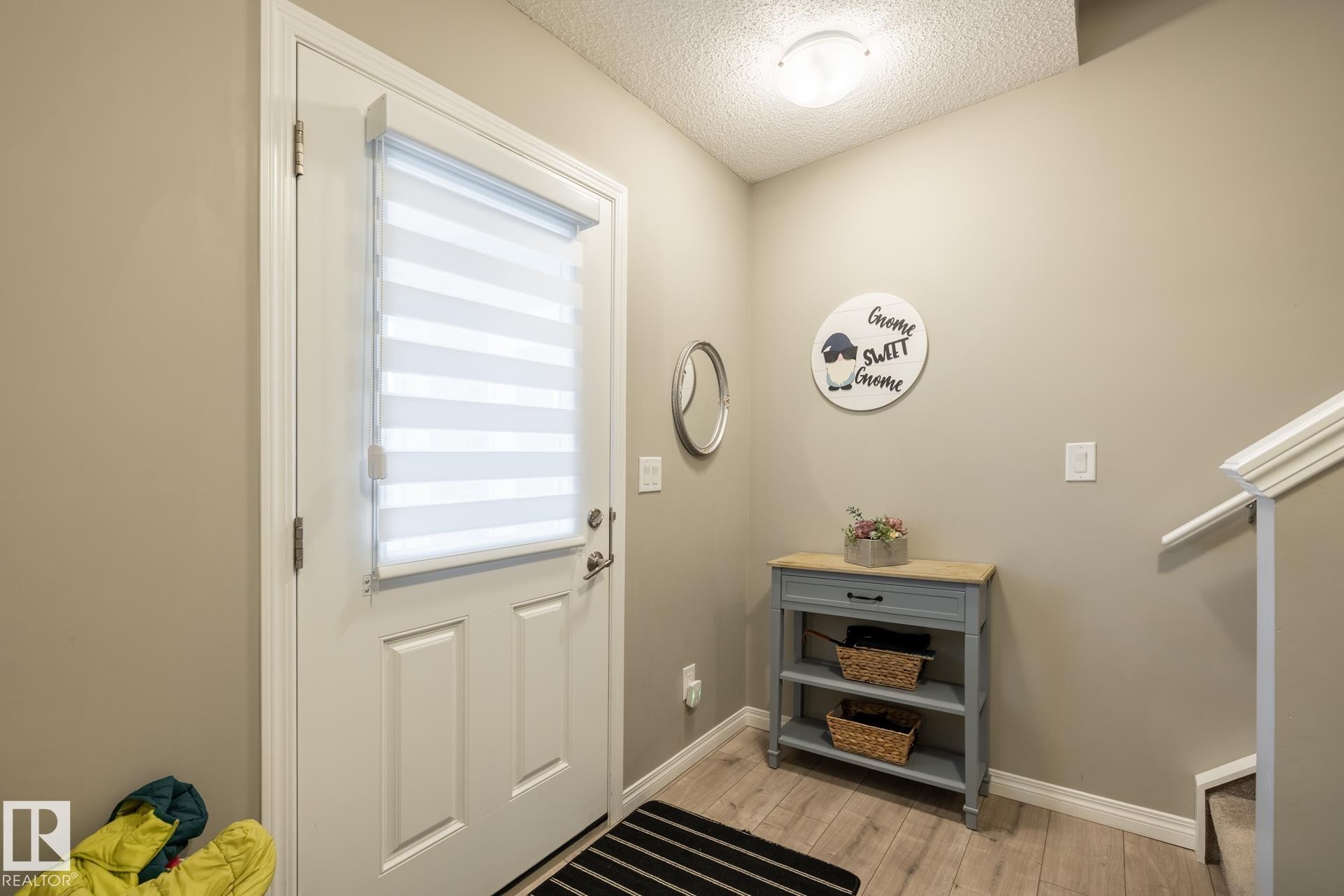 Doorway to outside with stairs, wood finished floors, and a textured ceiling - 5 2072 Wonnacott Way, Edmonton, AB - Indoor Photo Showing Other Room