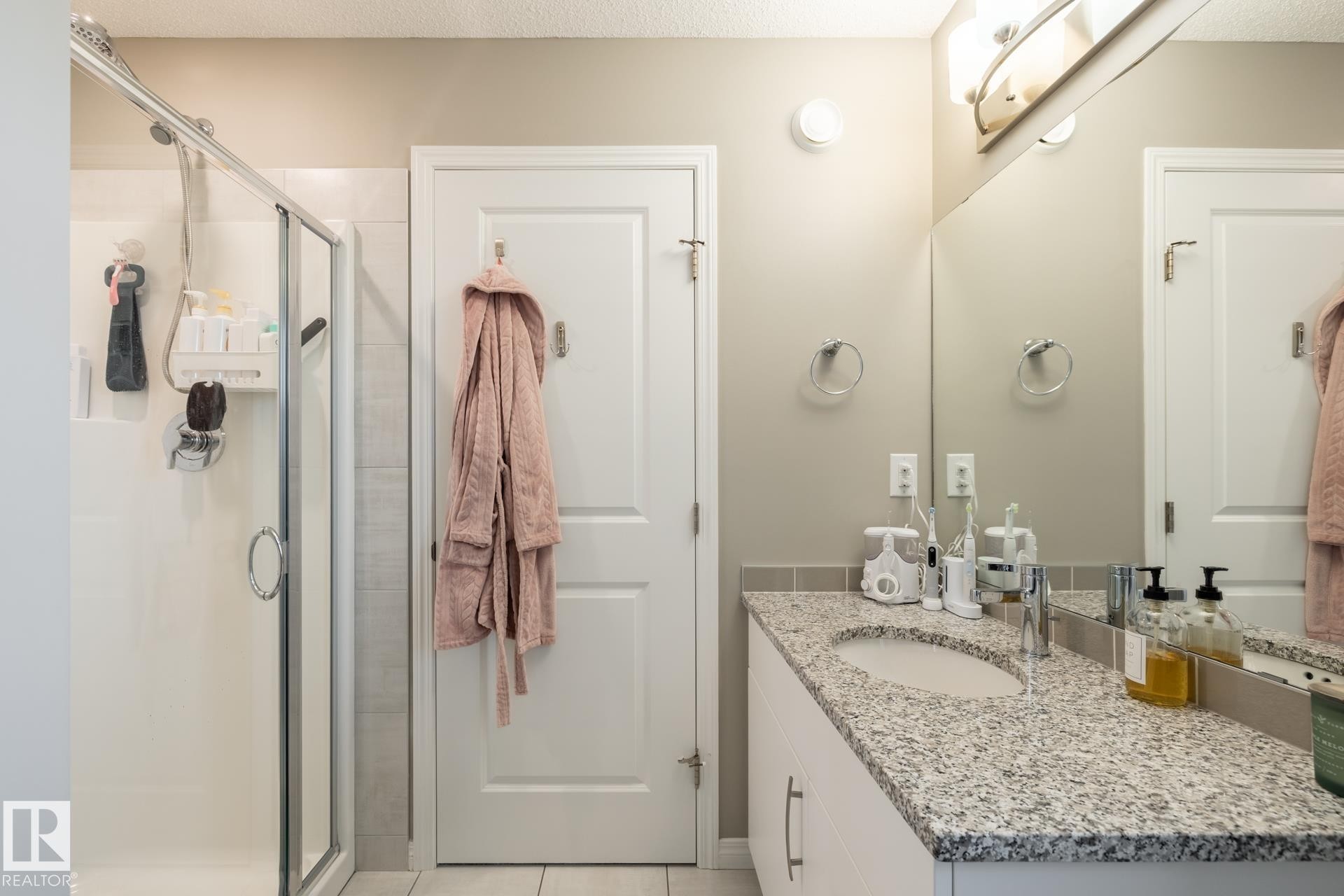 Full bathroom featuring vanity, a shower stall, light tile patterned flooring, and a textured ceiling - 5 2072 Wonnacott Way, Edmonton, AB - Indoor Photo Showing Bathroom