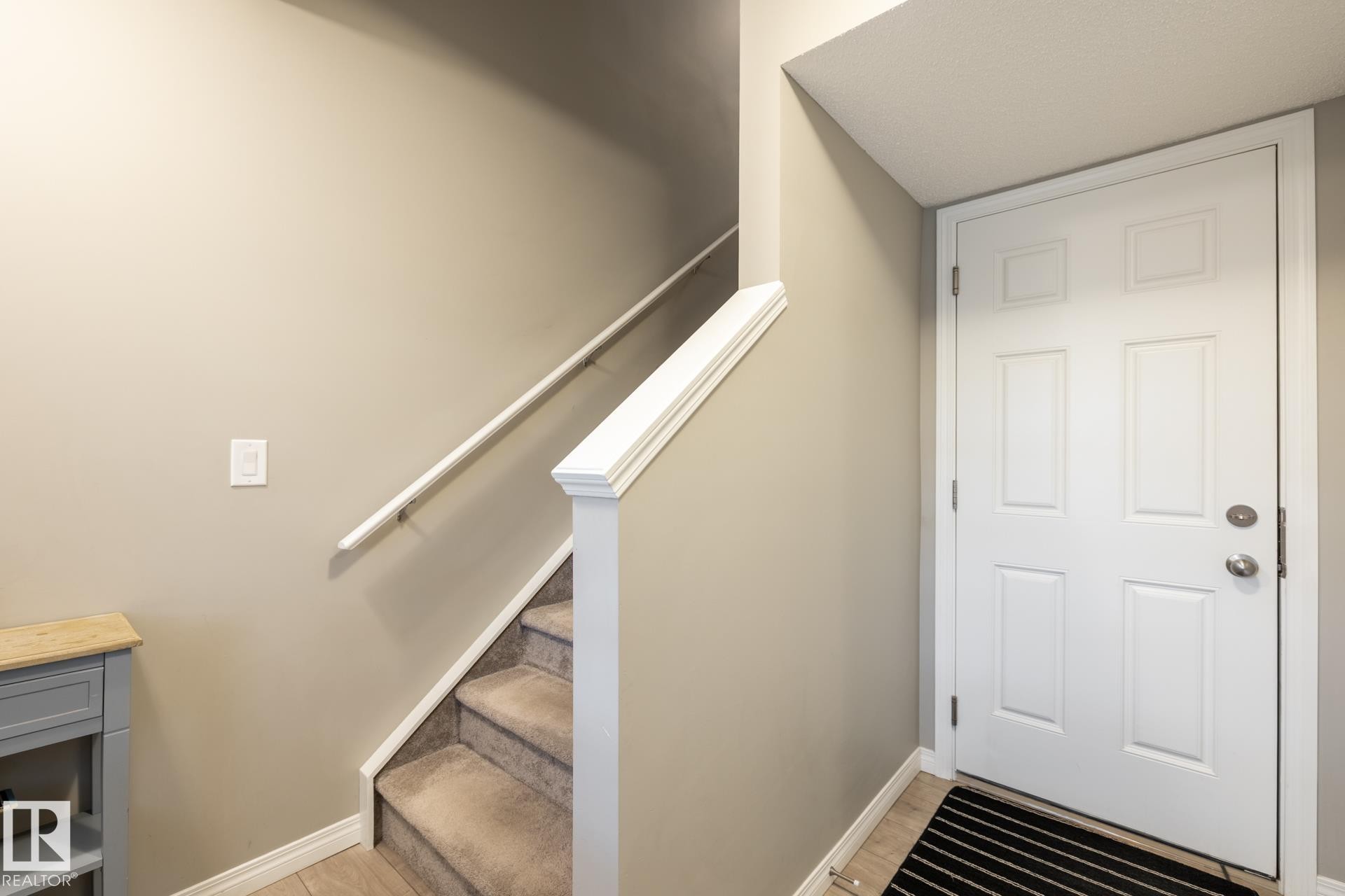 Stairway featuring baseboards and wood finished floors - 5 2072 Wonnacott Way, Edmonton, AB - Indoor Photo Showing Other Room