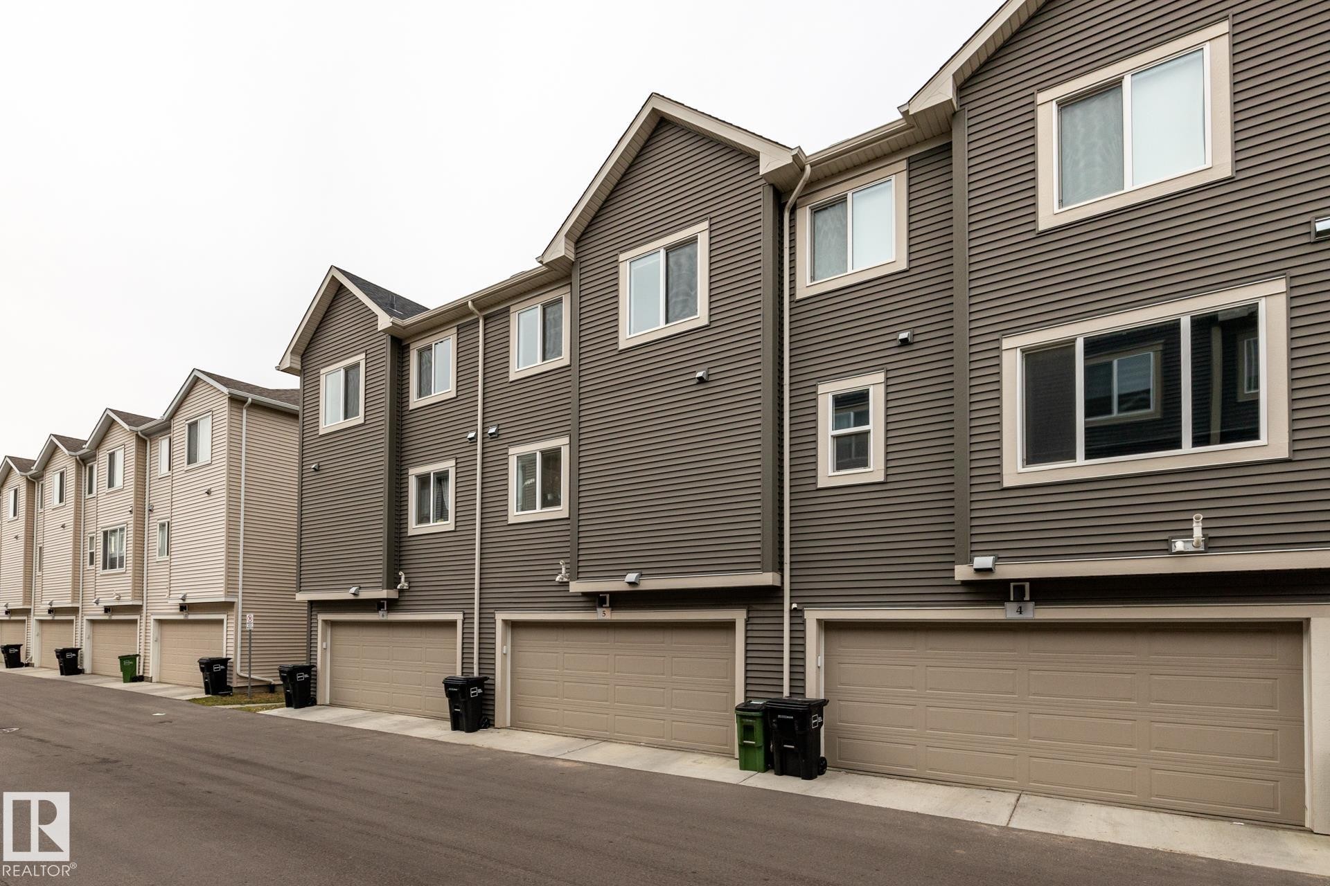 Back of house with a garage and a residential view - 5 2072 Wonnacott Way, Edmonton, AB - Outdoor