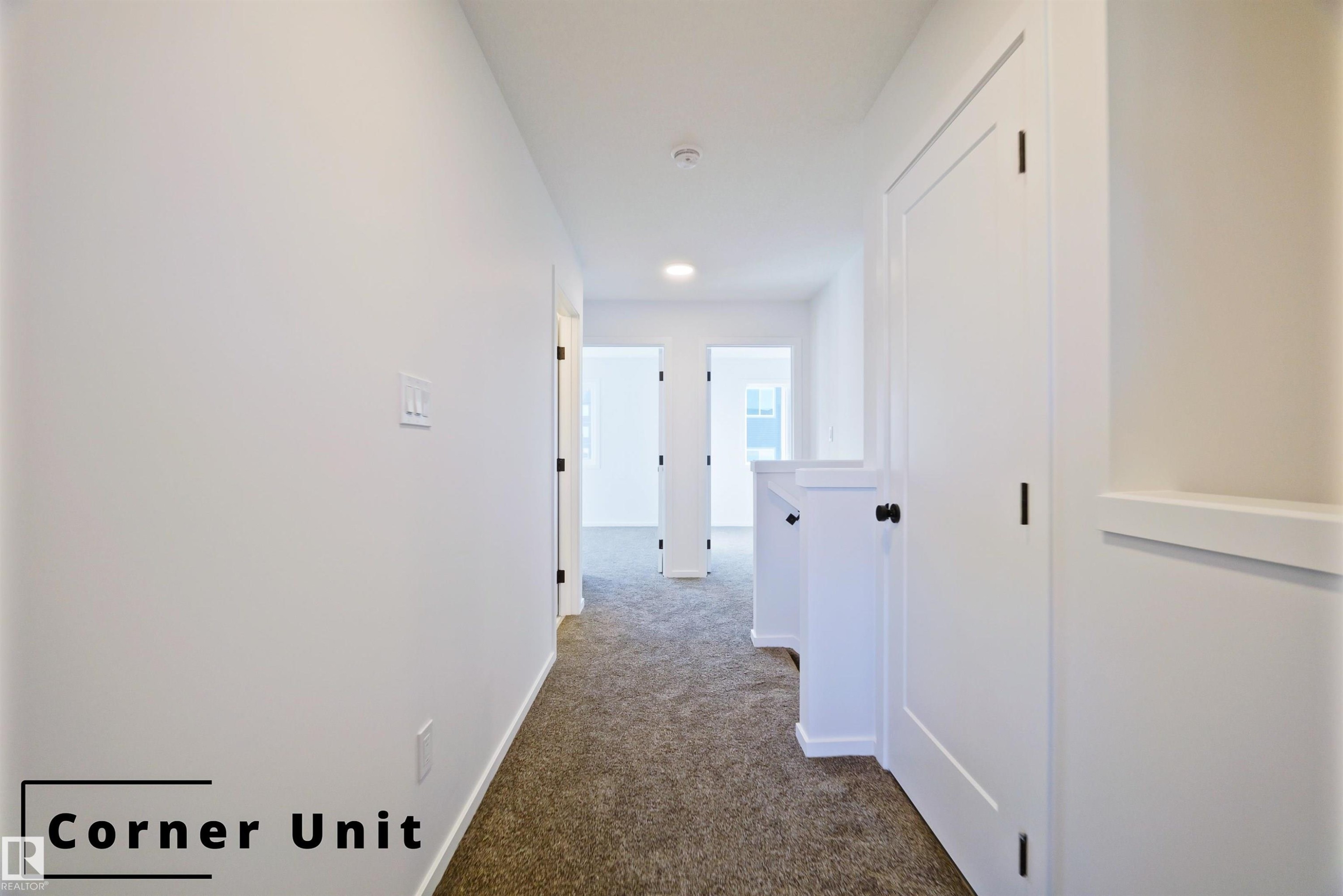 Corridor with dark colored carpet and baseboards - 7585 174A Avenue, Edmonton, AB - Indoor Photo Showing Other Room