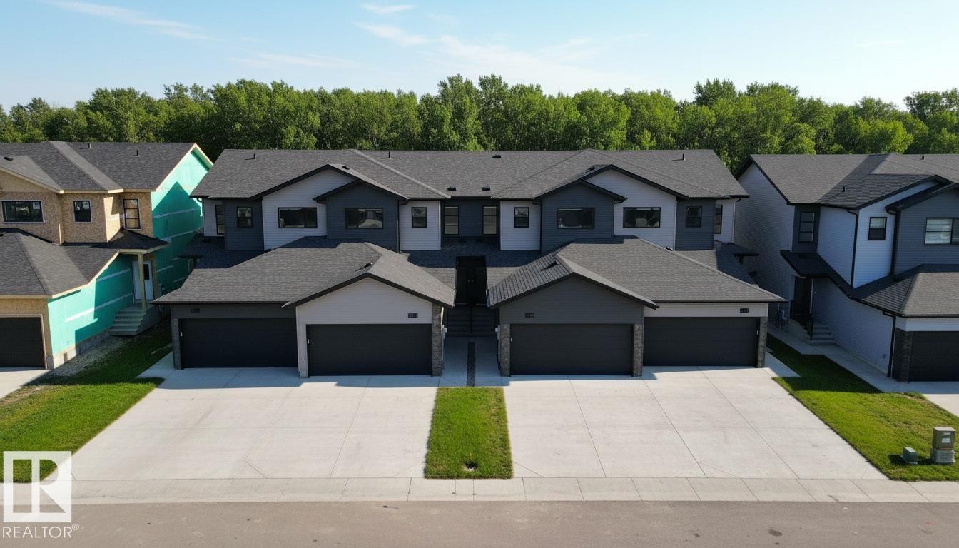 View of front of house featuring concrete driveway, roof with shingles, and a residential view - 7585 174A Avenue, Edmonton, AB - Outdoor With Facade
