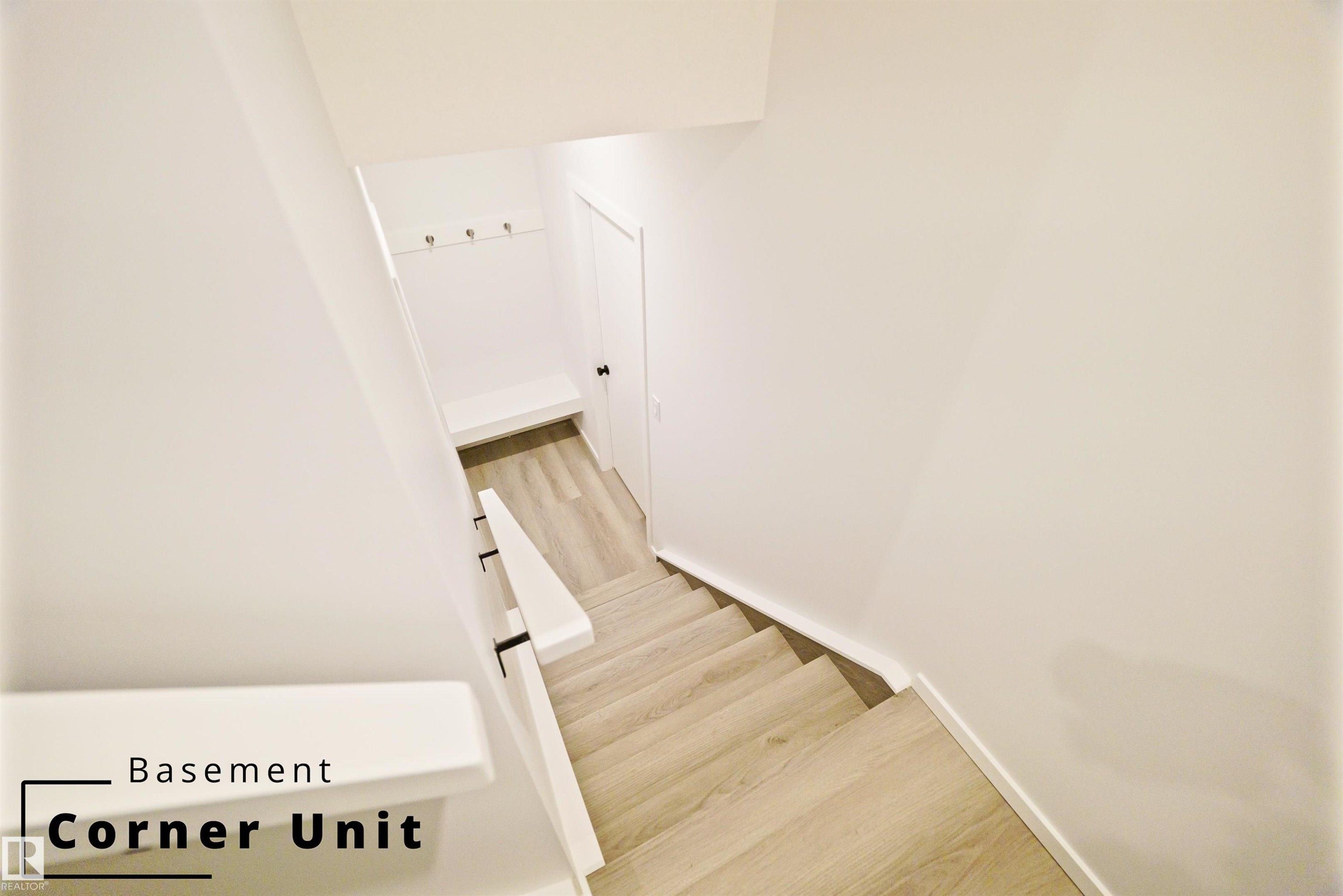 Staircase with wood finished floors - 7585 174A Avenue, Edmonton, AB - Indoor Photo Showing Other Room
