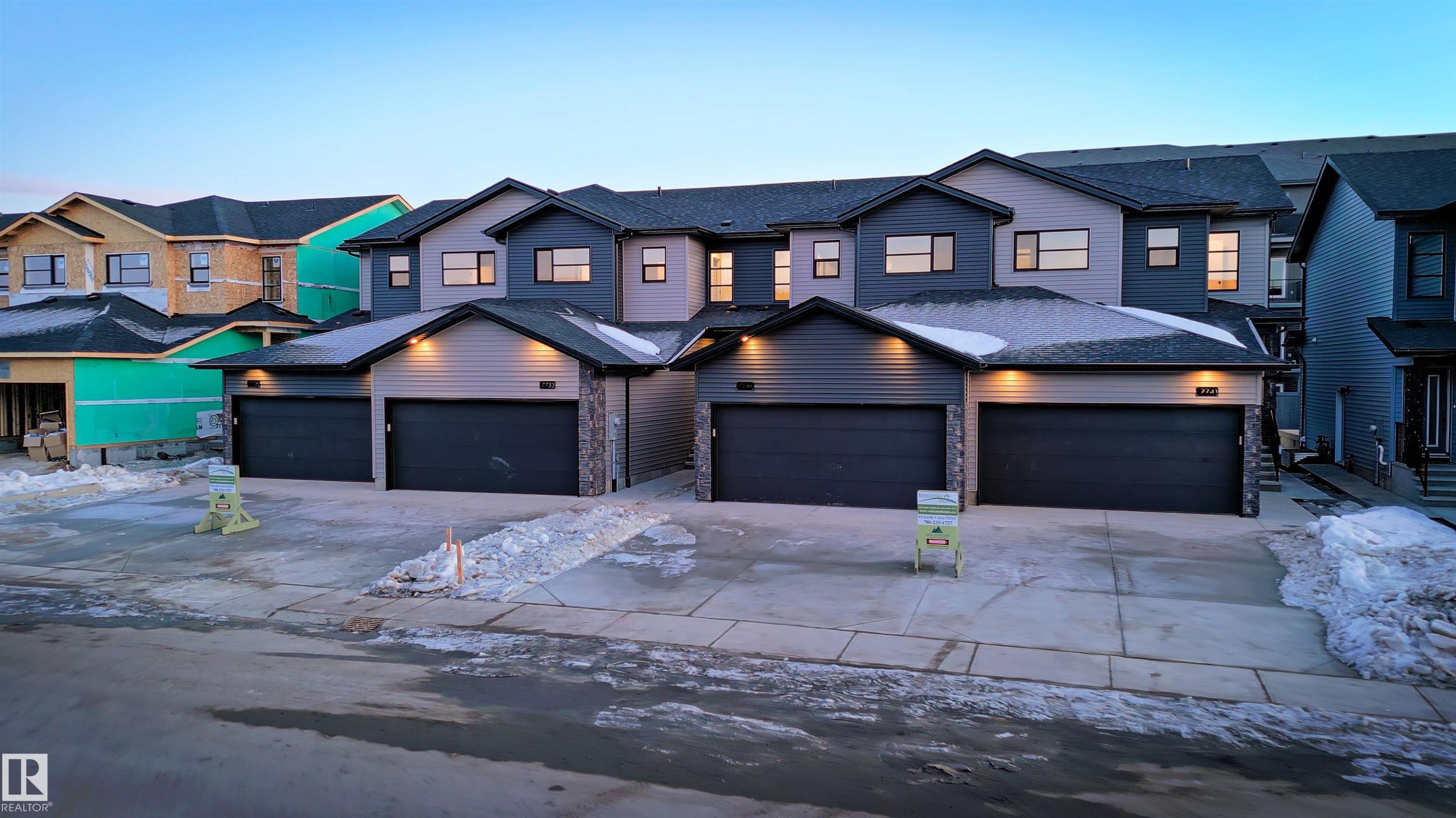 View of front of home with driveway, a shingled roof, and stone siding - 7585 174A Avenue, Edmonton, AB - Outdoor With Facade