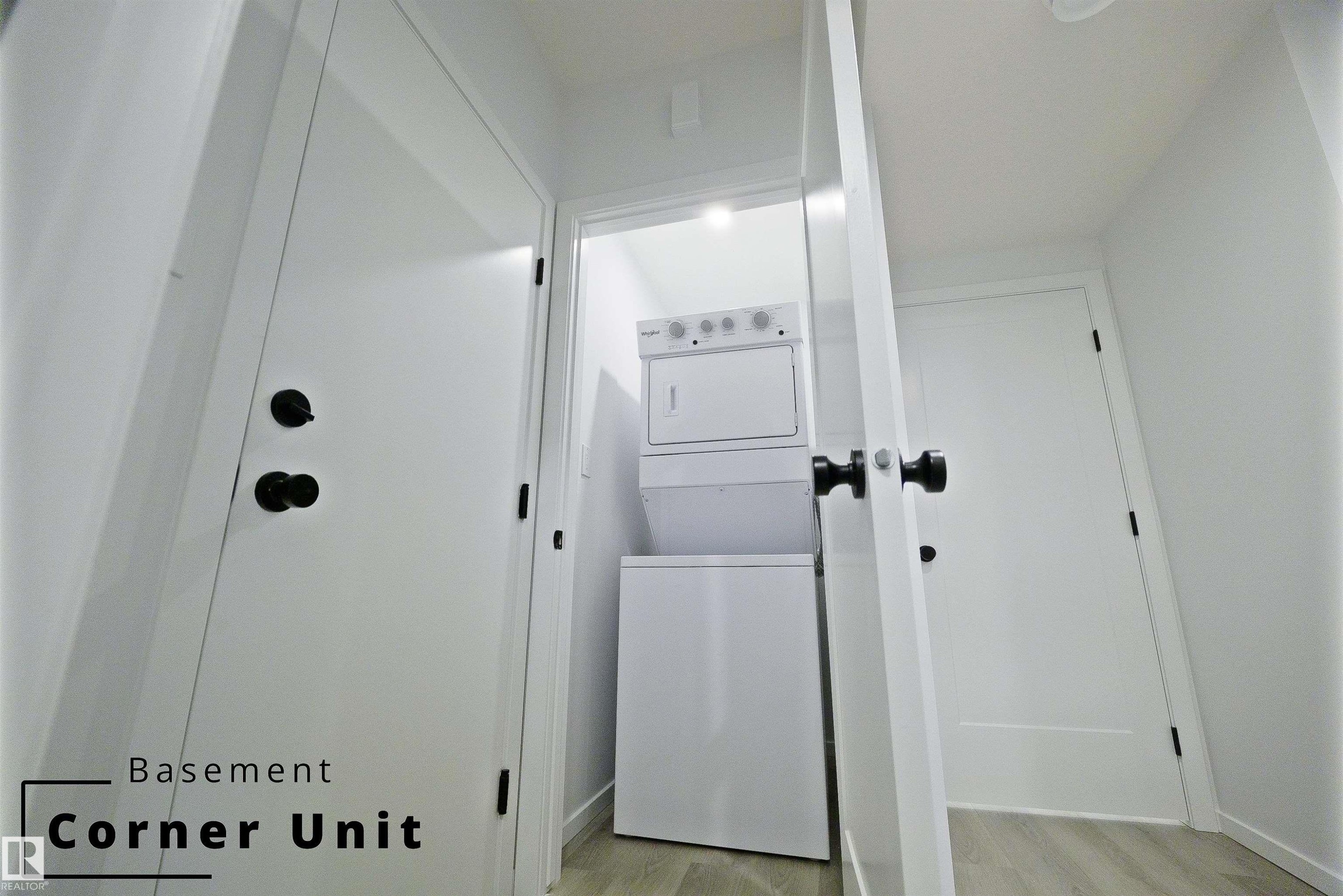 Laundry area with light wood-style flooring and estacked washer and dryer - 7585 174A Avenue, Edmonton, AB - Indoor Photo Showing Other Room