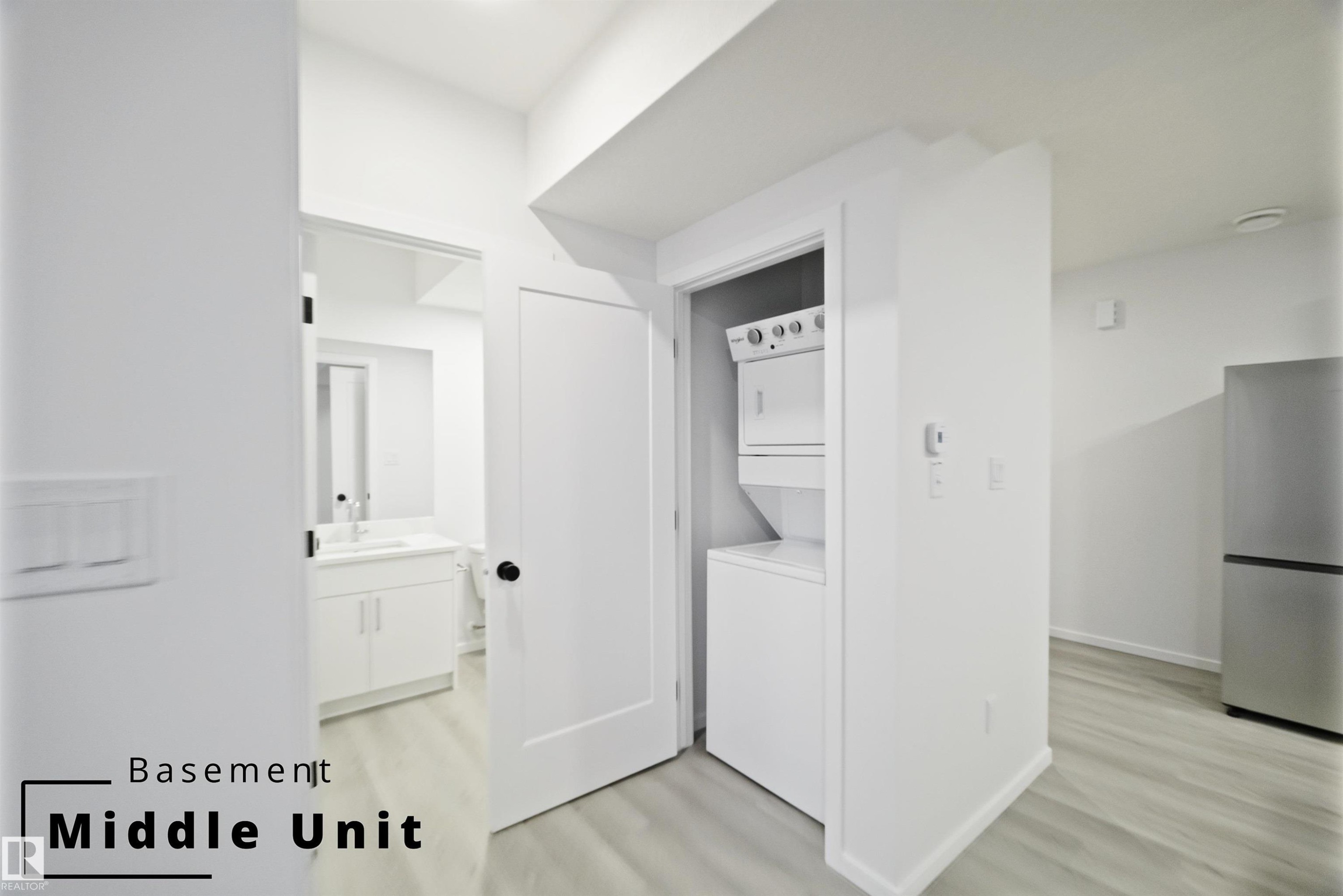 Laundry room featuring light wood-style floors and stacked washer / dryer - 7585 174A Avenue, Edmonton, AB - Indoor Photo Showing Laundry Room