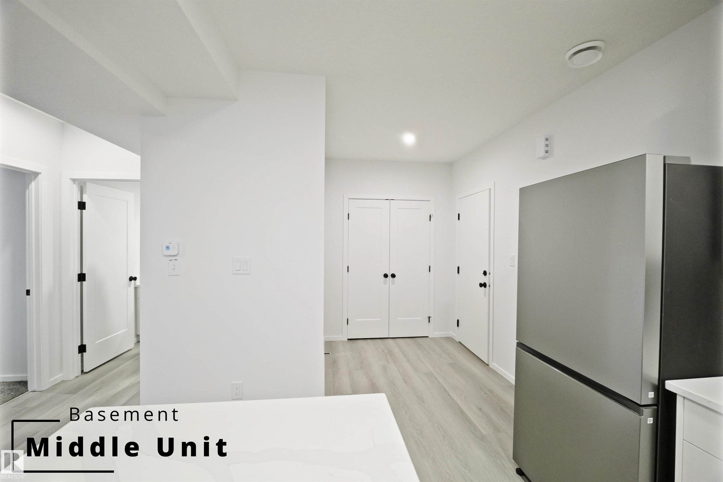 Kitchen with freestanding refrigerator, light wood-type flooring, light countertops, and recessed lighting - 7585 174A Avenue, Edmonton, AB - Indoor Photo Showing Other Room