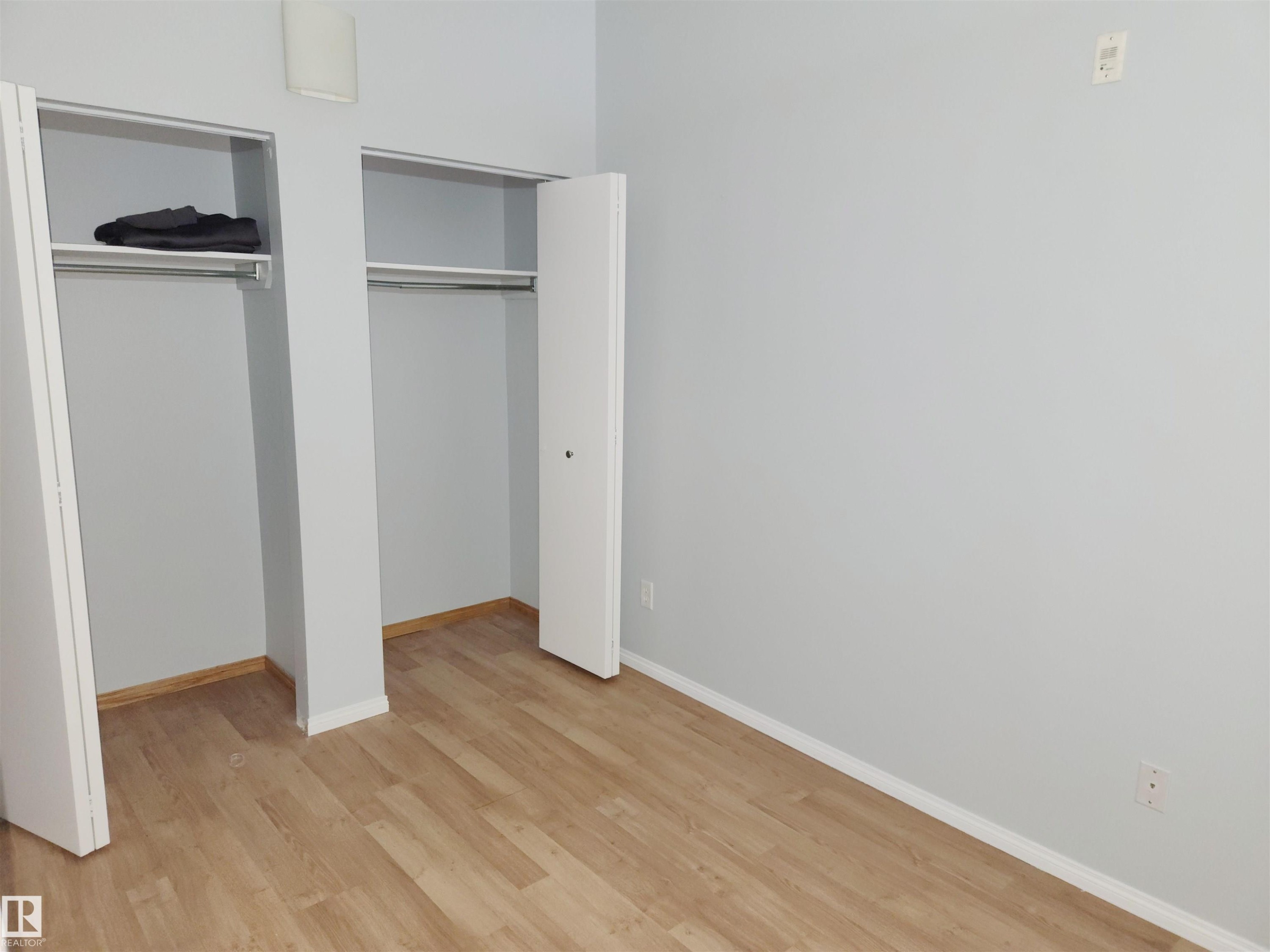 Unfurnished bedroom featuring two closets and light wood-style flooring - 1410 10024 Jasper Avenue, Edmonton, AB - Indoor Photo Showing Other Room