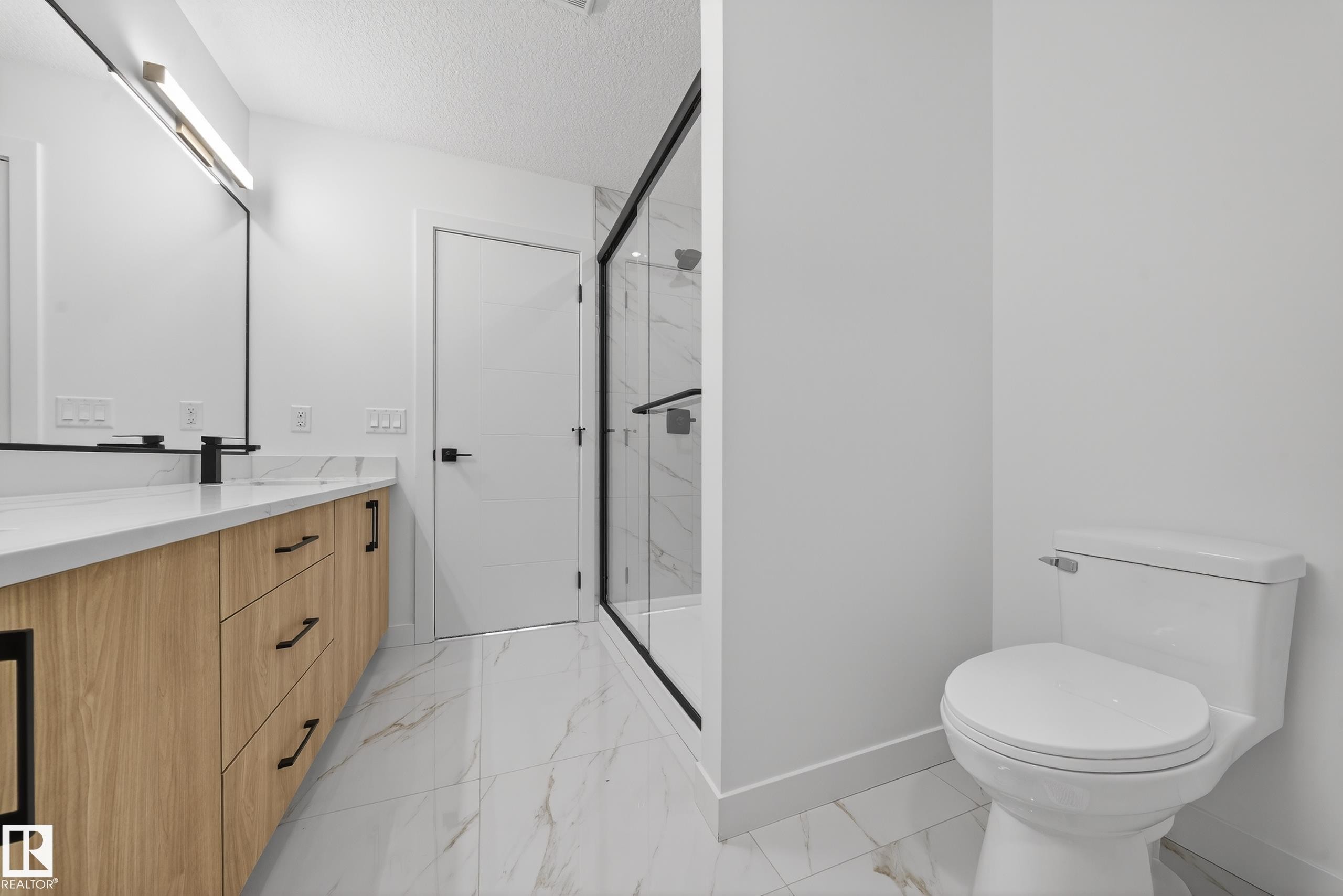 Bathroom with double vanity, a marble finish shower, light marble finish floors, and a textured ceiling - 129 Pierwyck Loop, Spruce Grove, AB - Indoor Photo Showing Bathroom