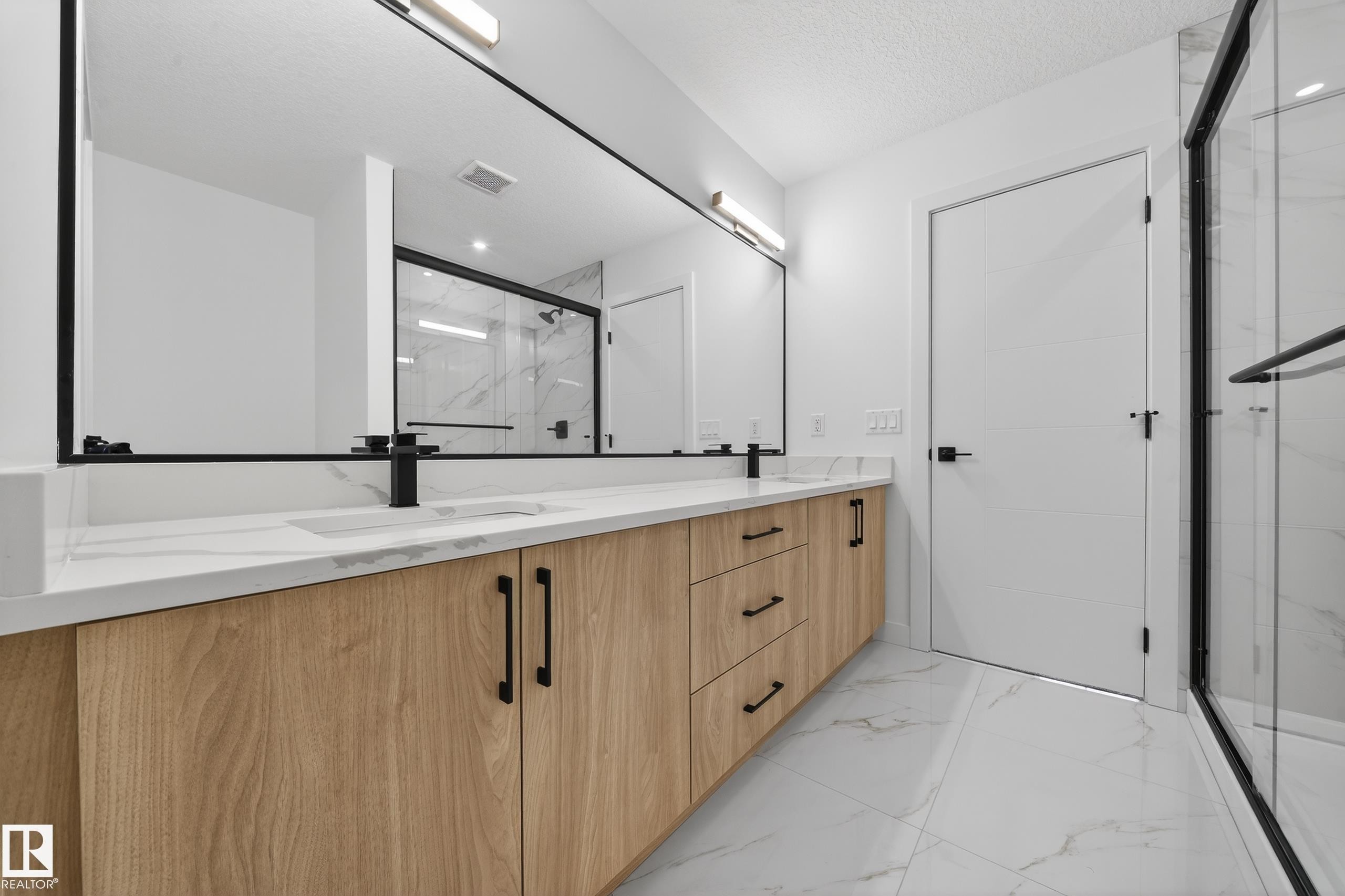 Bathroom with a marble finish shower, double vanity, light marble finish flooring, and a textured ceiling - 129 Pierwyck Loop, Spruce Grove, AB - Indoor