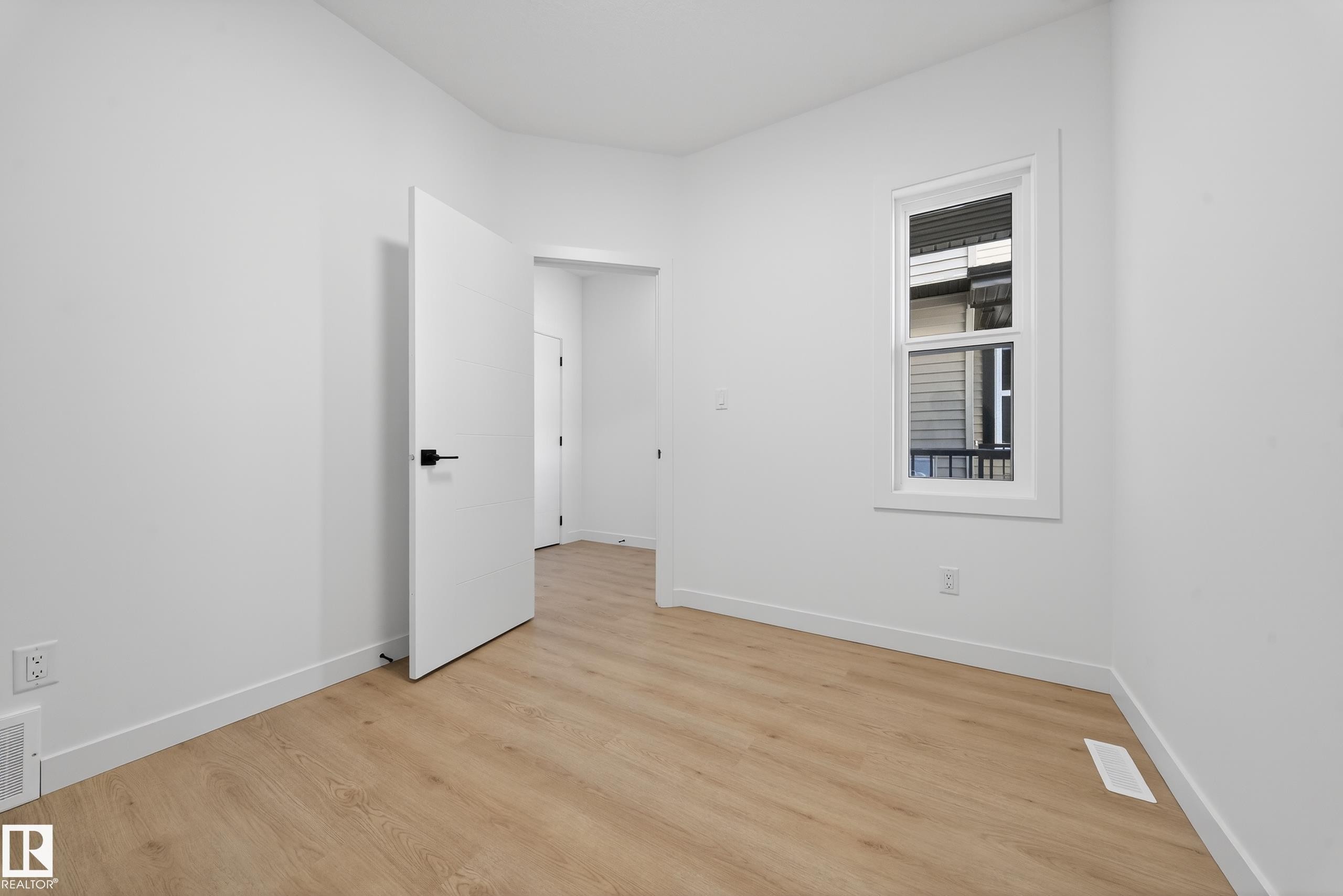 Empty room featuring light wood-type flooring and baseboards - 129 Pierwyck Loop, Spruce Grove, AB - Indoor Photo Showing Other Room