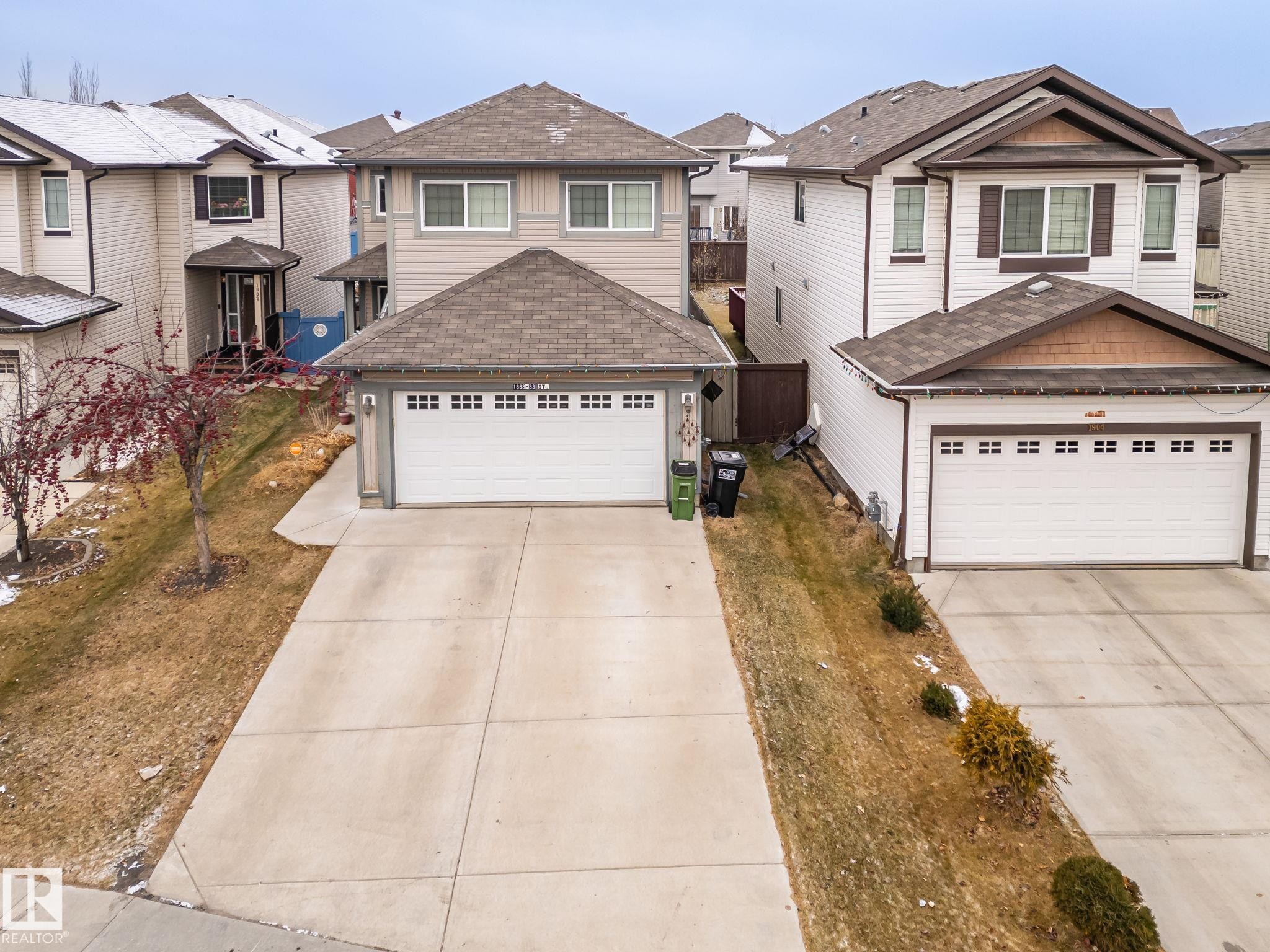 View of front of home featuring a shingled roof, a garage, a residential view, and concrete driveway - 1888 33 Street, Edmonton, AB - Outdoor With Facade