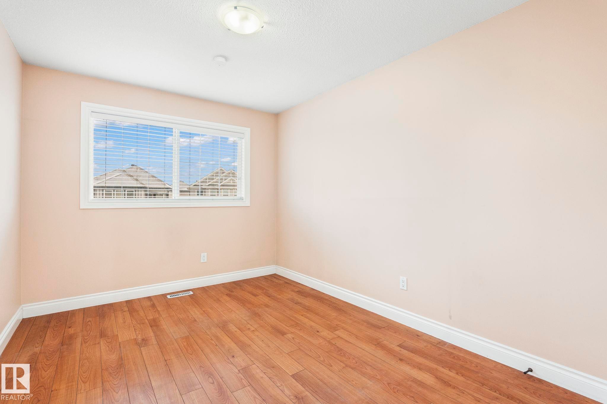 Unfurnished room featuring baseboards and light wood-type flooring - 1888 33 Street, Edmonton, AB - Indoor Photo Showing Other Room