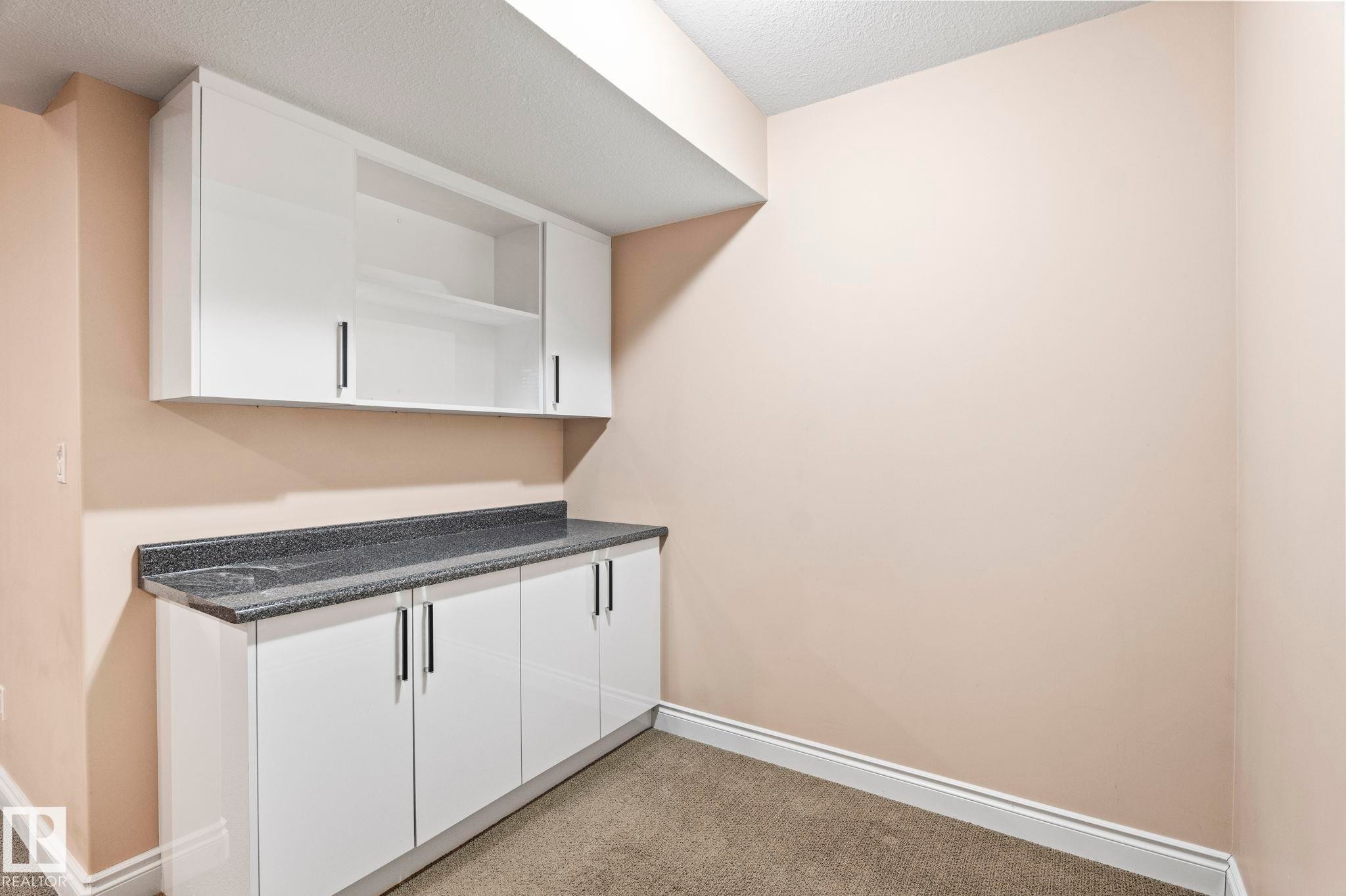Kitchen with white cabinetry, light colored carpet, open shelves, and a textured ceiling - 1888 33 Street, Edmonton, AB - Indoor Photo Showing Other Room